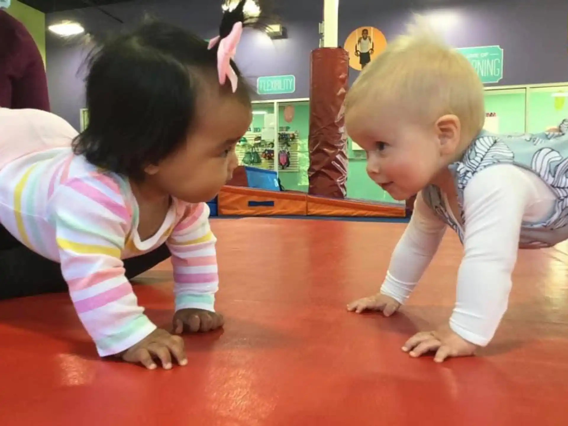 a couple of children playing on a red table
