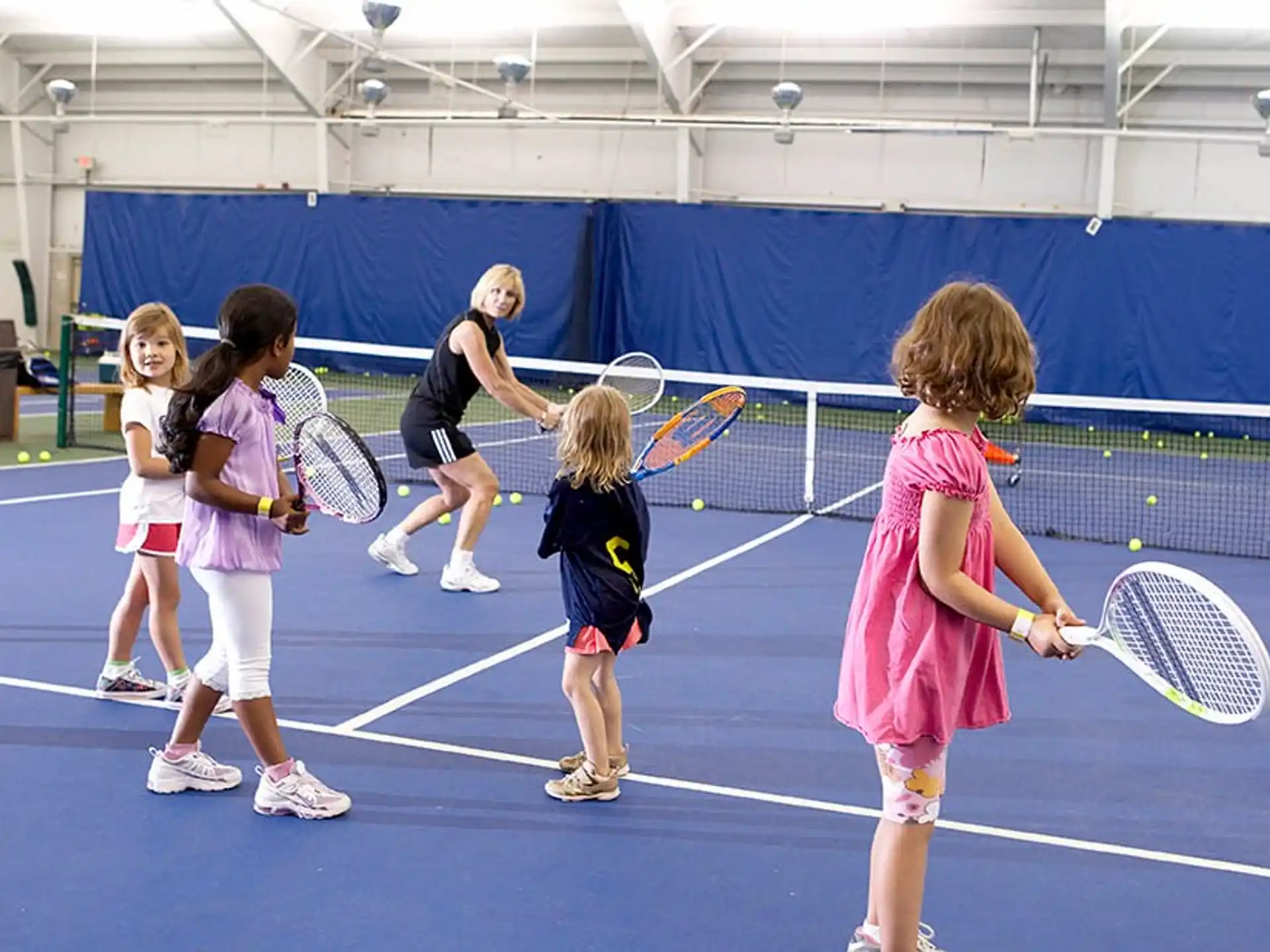 a group of kids playing tennis