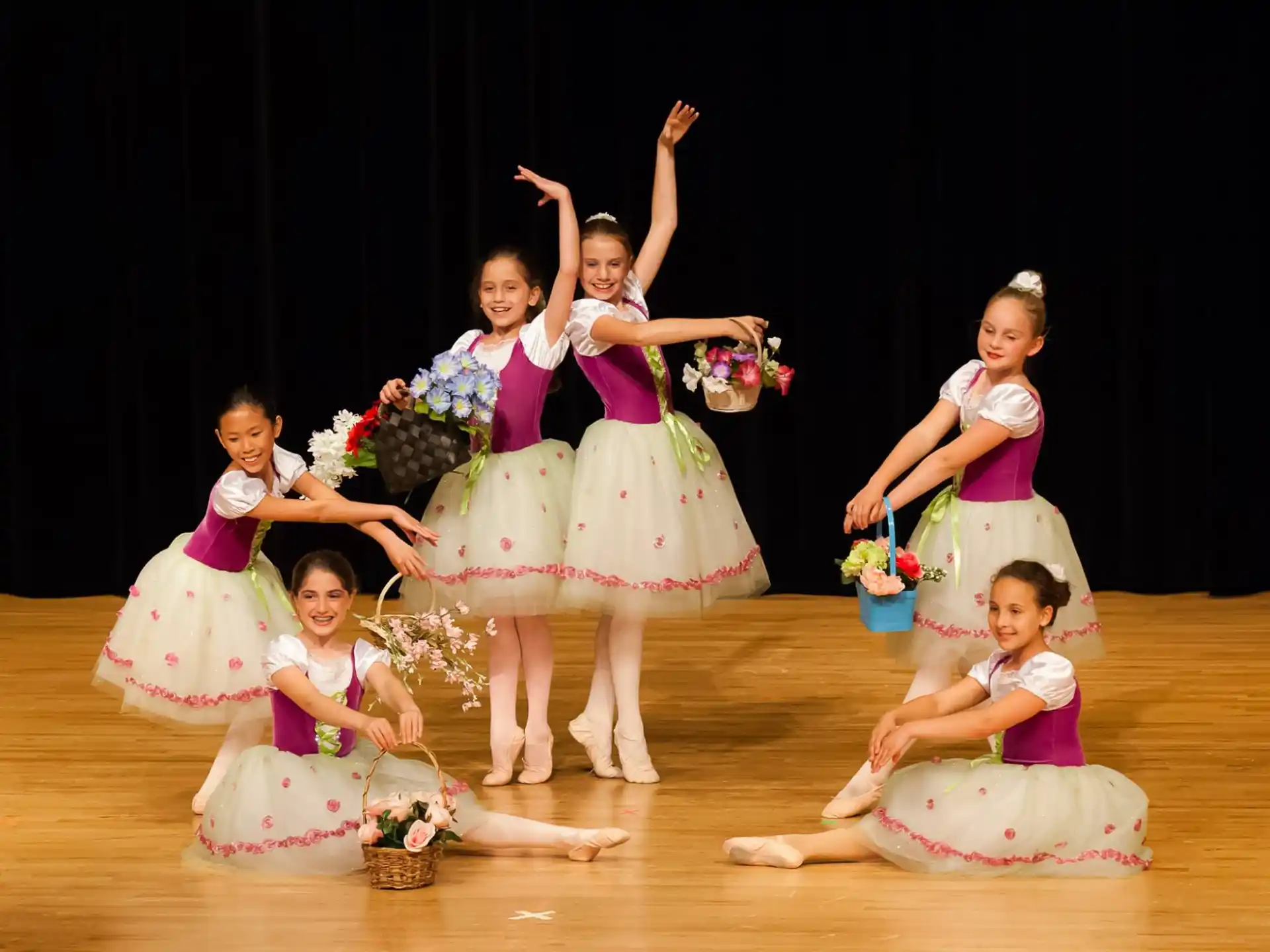 a group of girls in dresses and dresses holding flowers