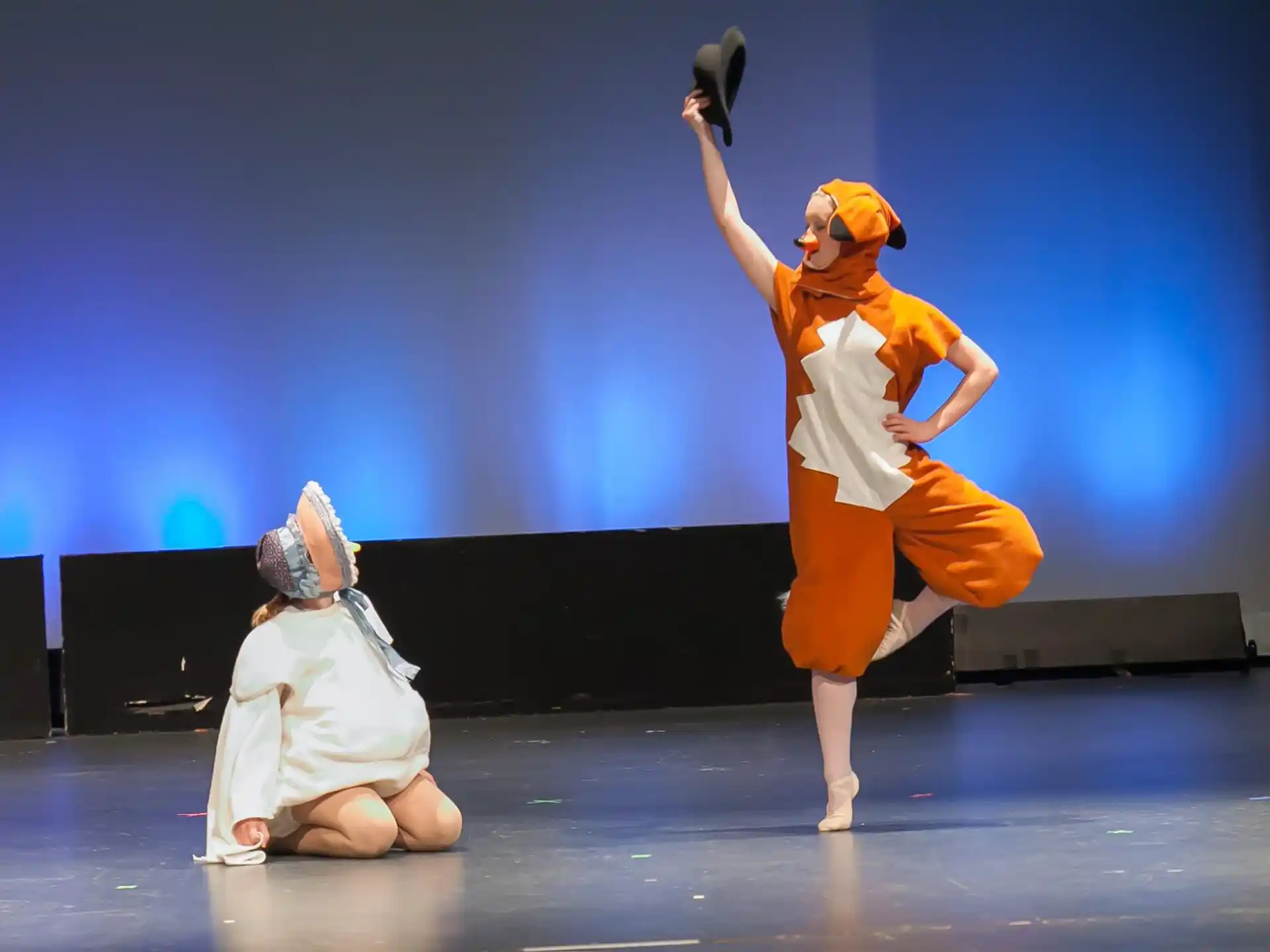 a person in an orange garment holding a gun and a child in a white shirt