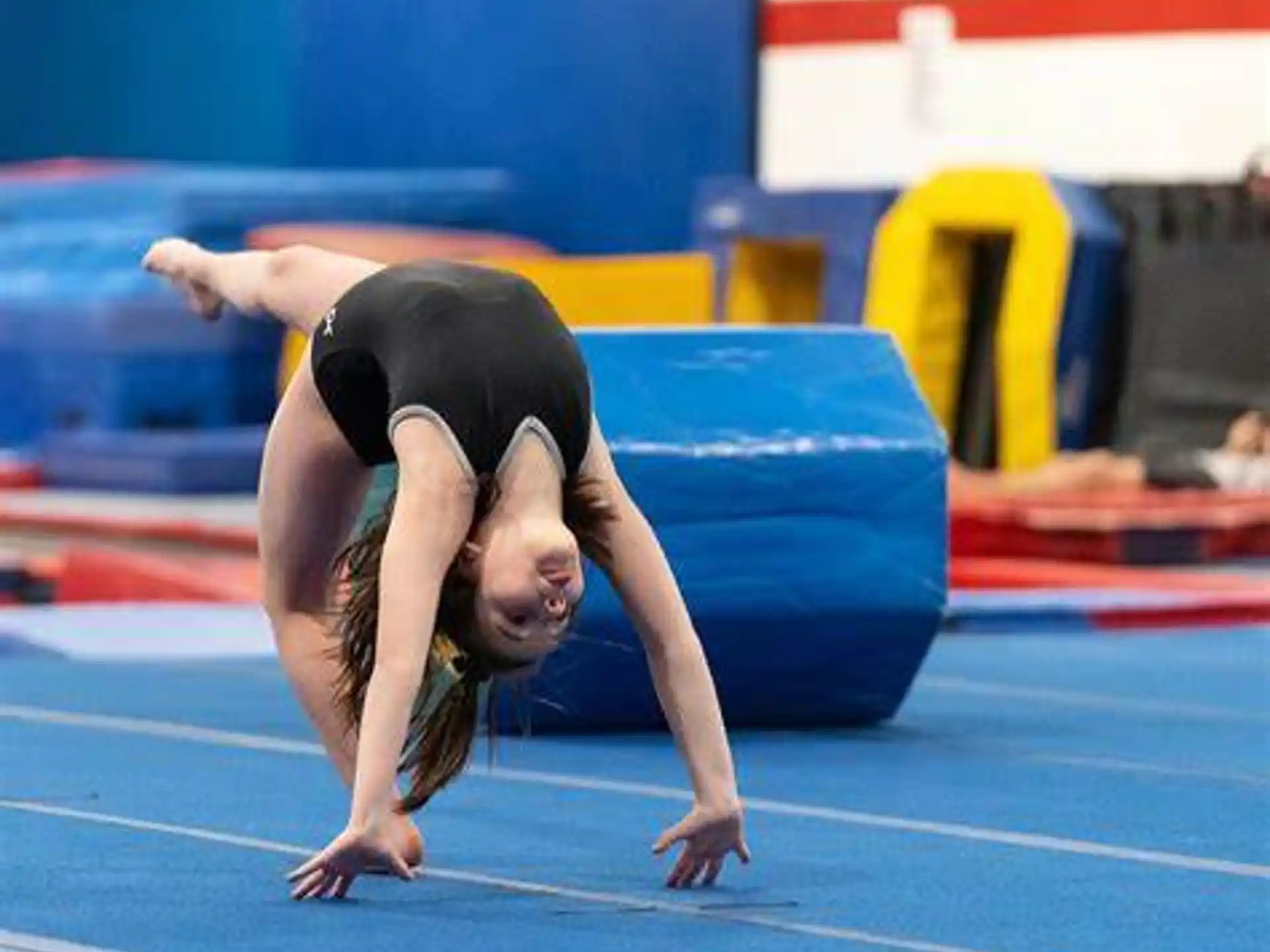 a woman doing a handstand on a mat