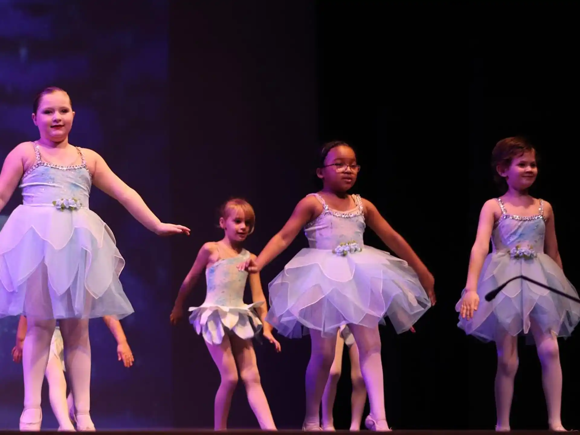 a group of girls in dresses dancing