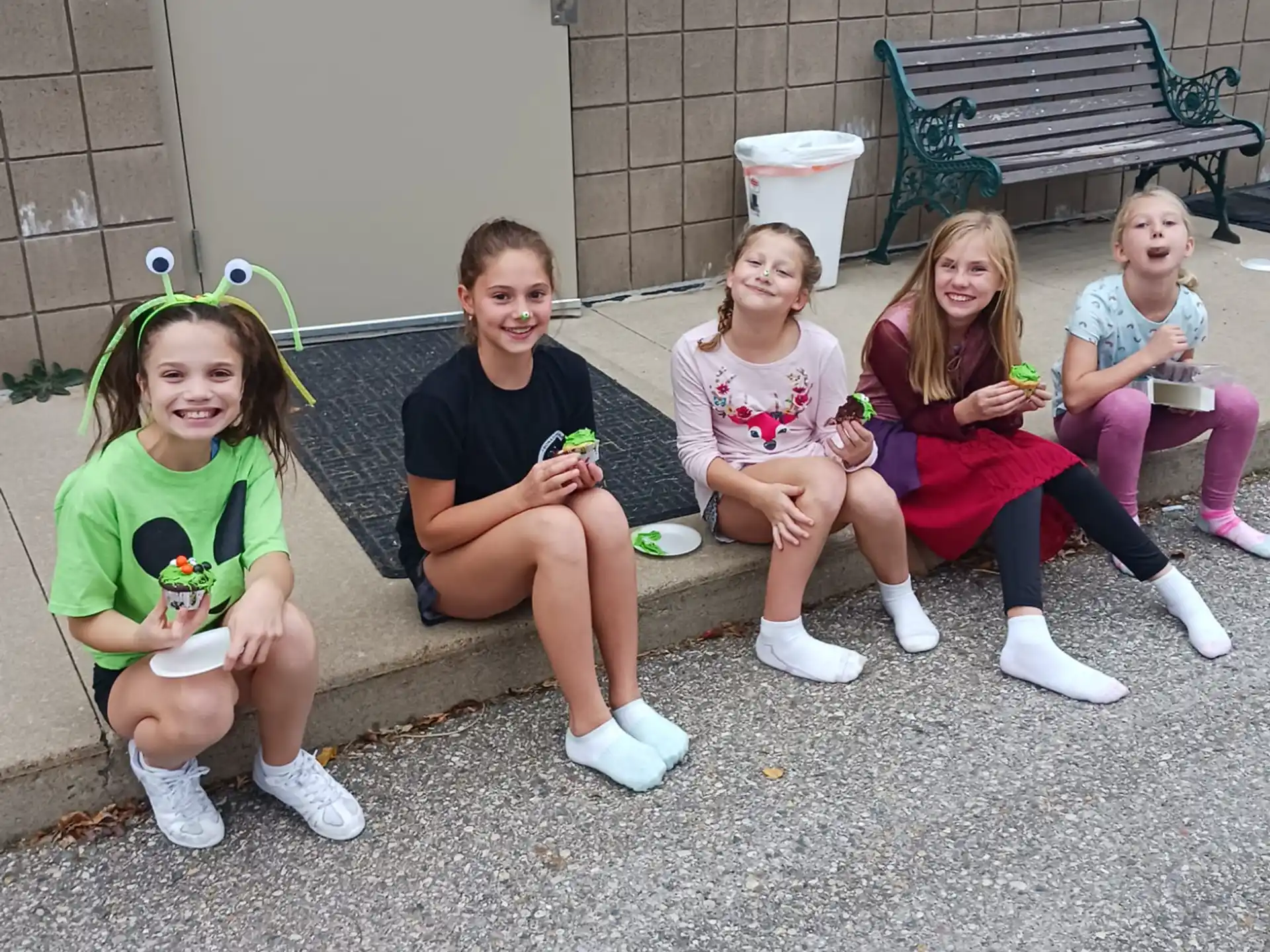a group of girls sitting on a bench