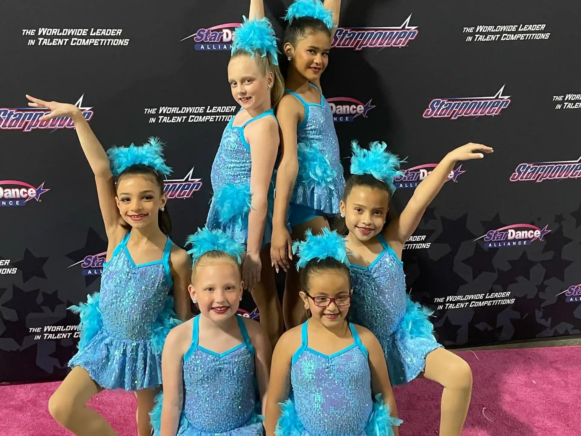 a group of girls in blue dresses
