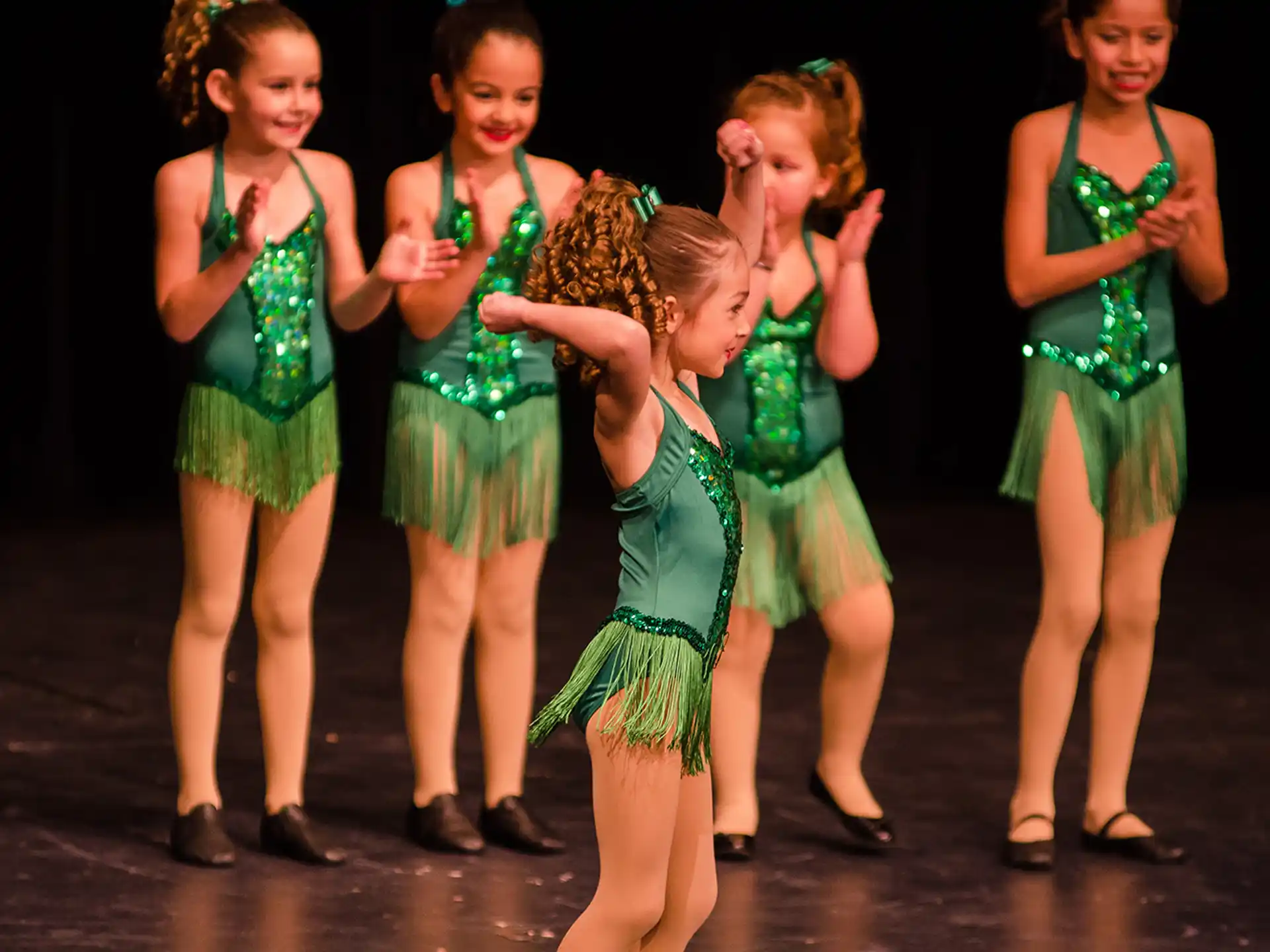 a group of girls in green dresses