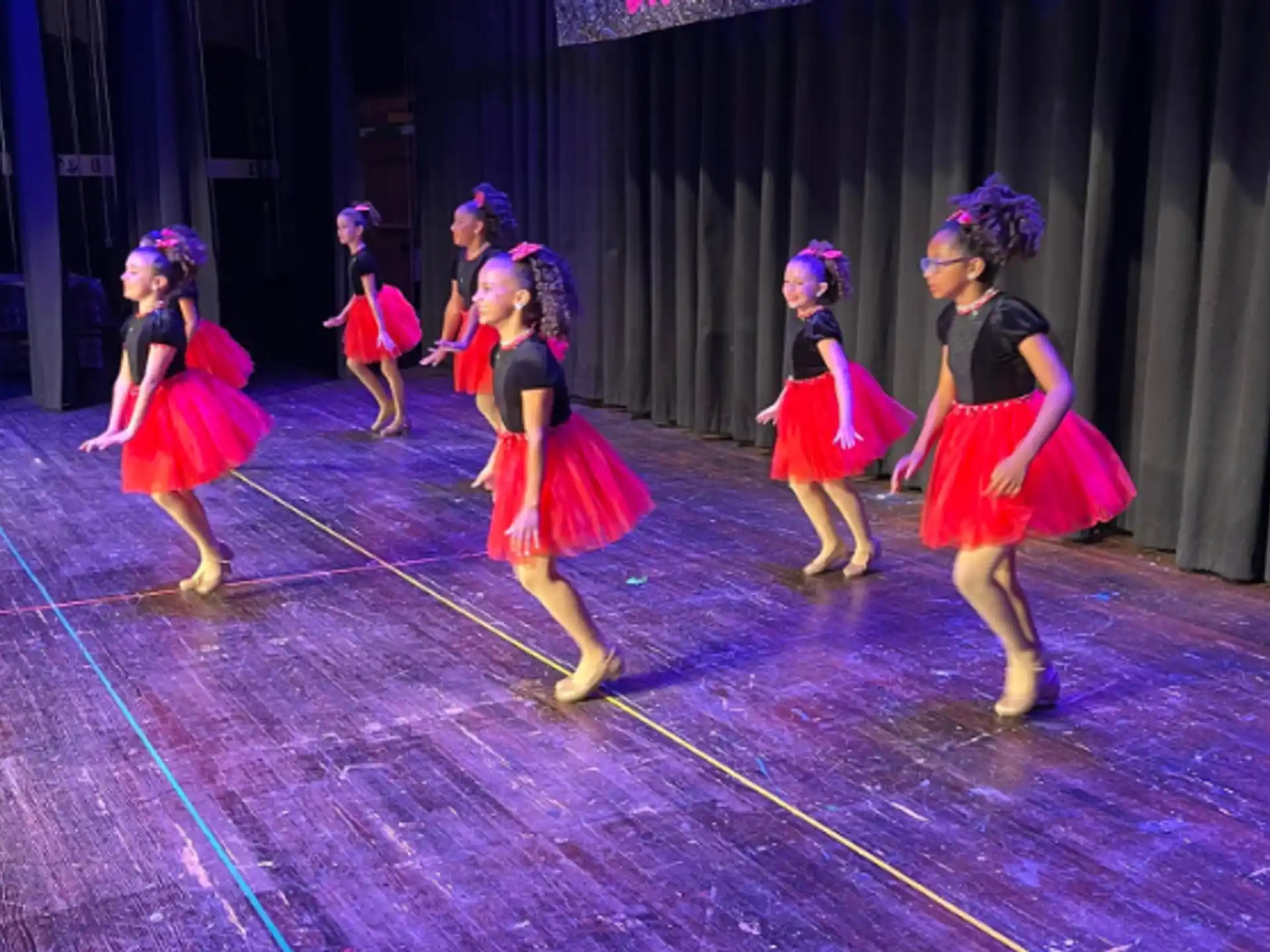 a group of girls dancing on a stage