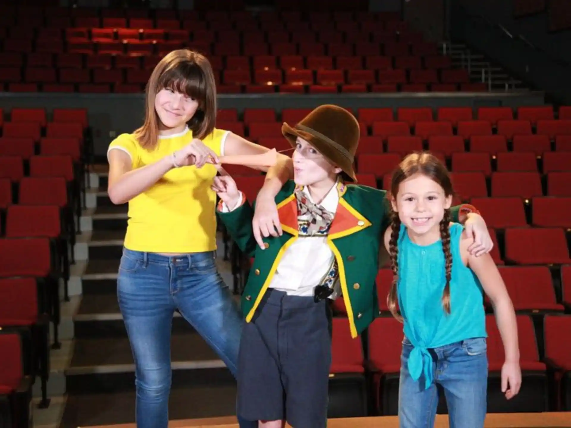 a group of women posing for a photo in a theater