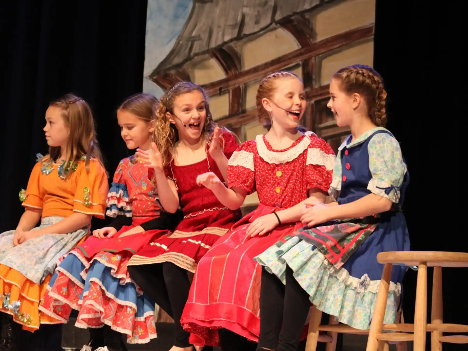 a group of women sitting on stools
