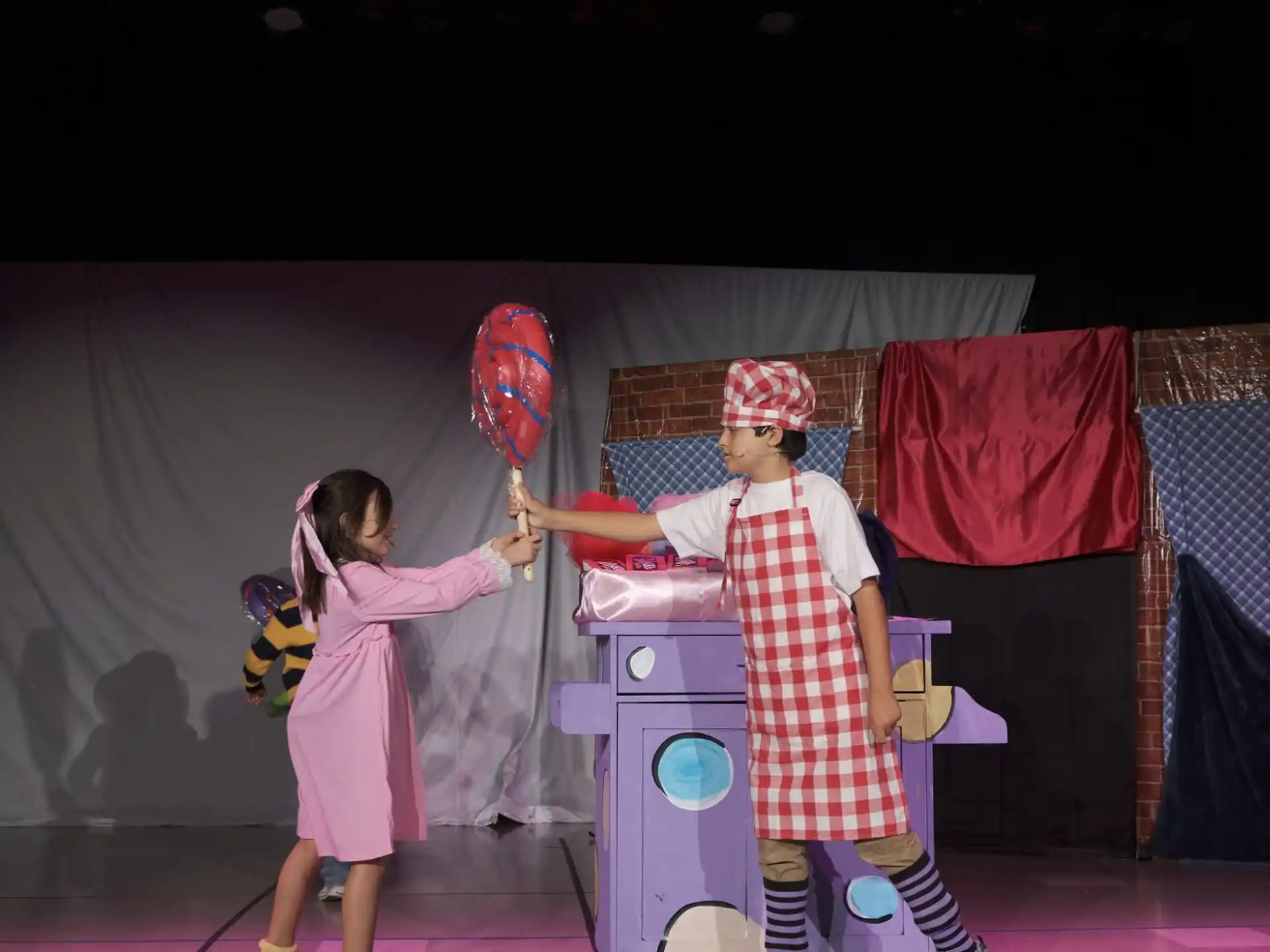 a person and a girl on a stage with a microphone
