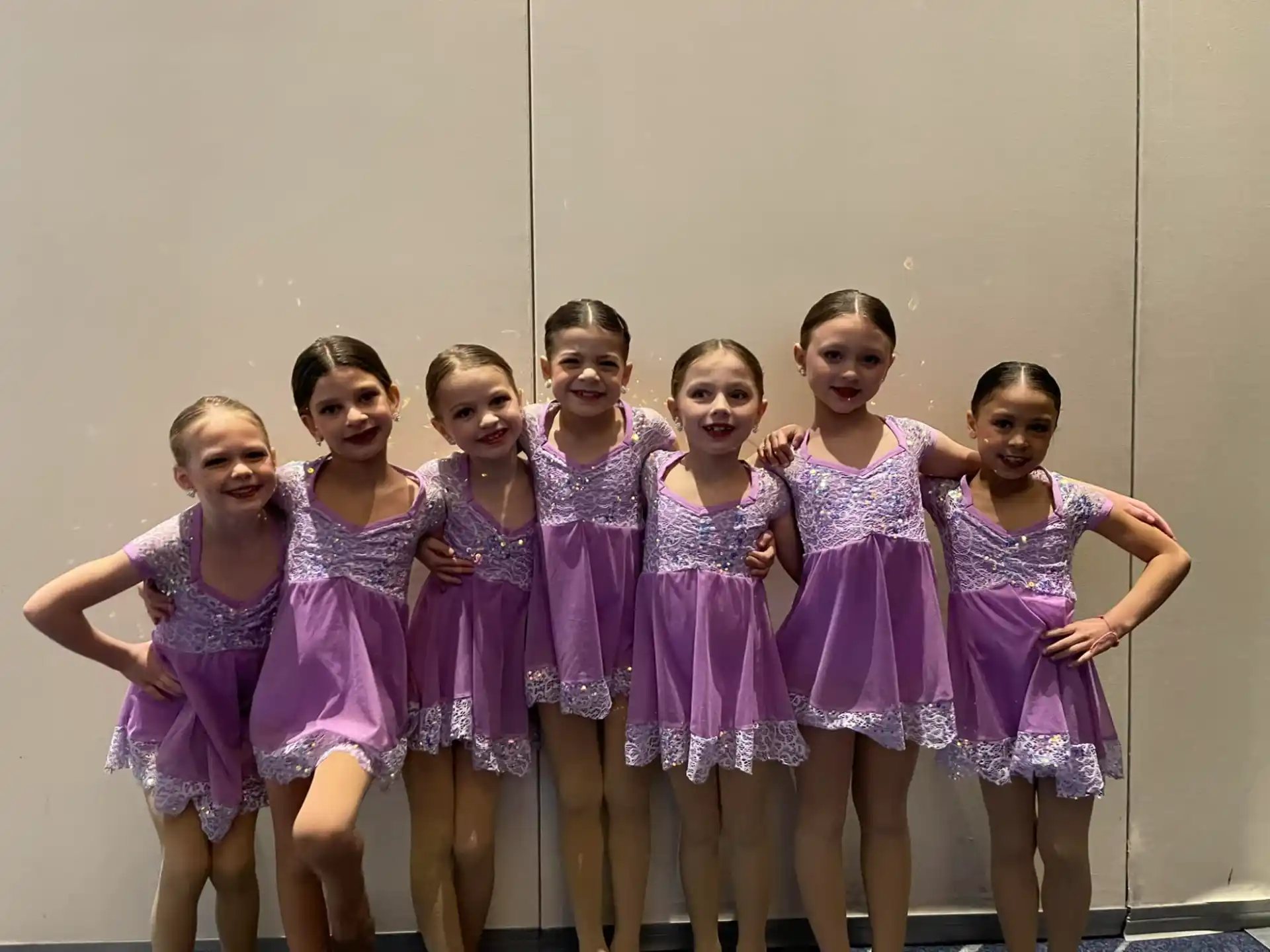 a group of girls in purple dresses