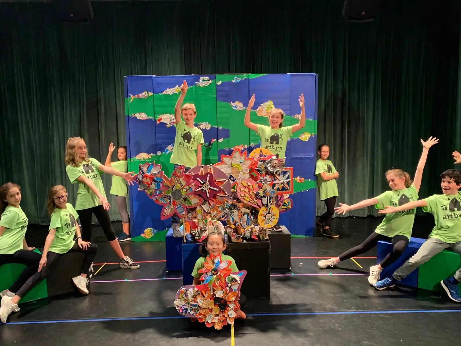 a group of people in green shirts dancing on a stage