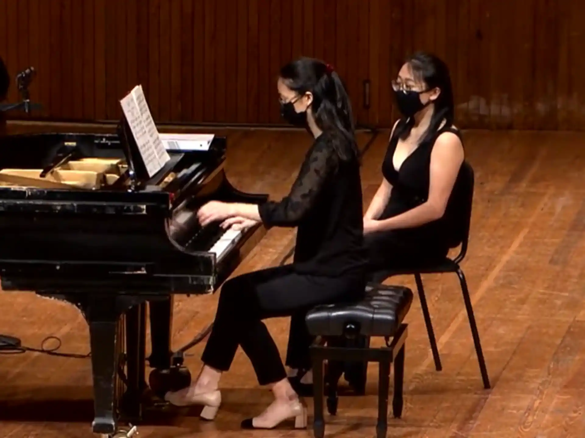 a couple of women playing piano