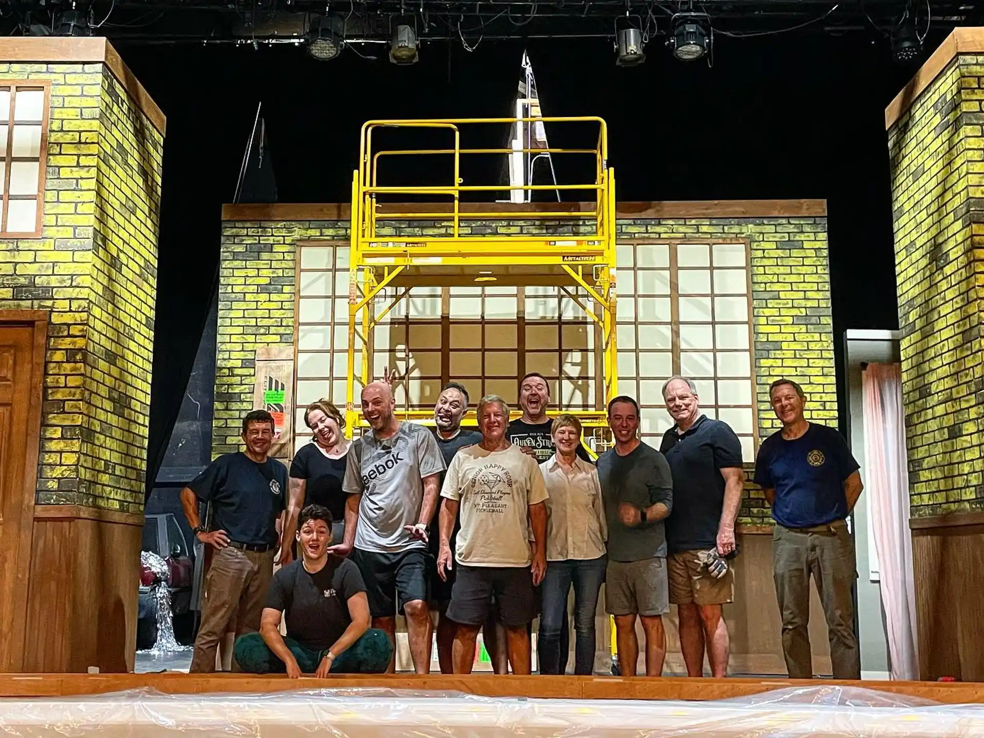 a group of people posing for a photo in front of a construction site