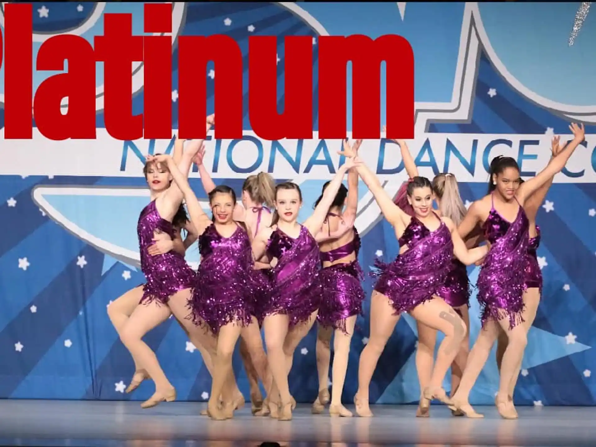 a group of women in purple and white dresses on a stage