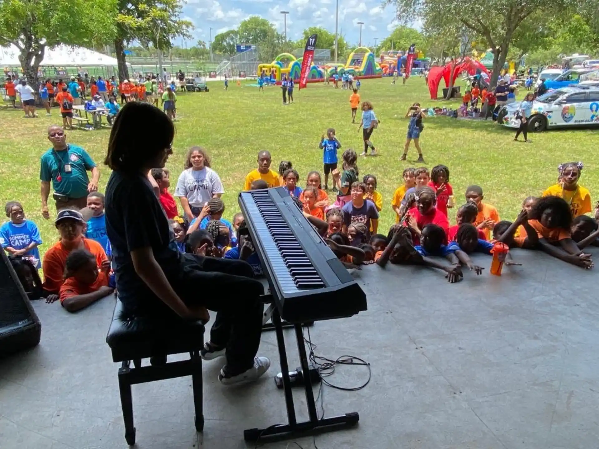 a person playing a piano in front of a group of children