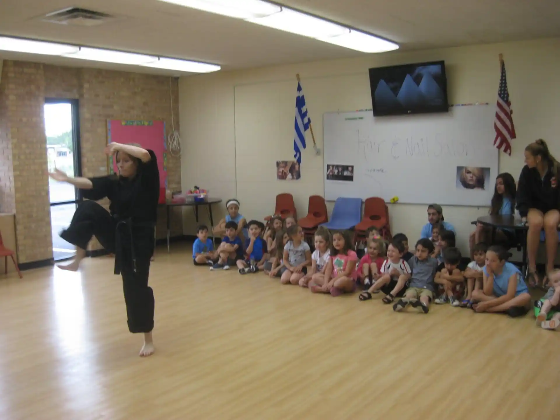 a person standing in front of a group of children sitting on the floor