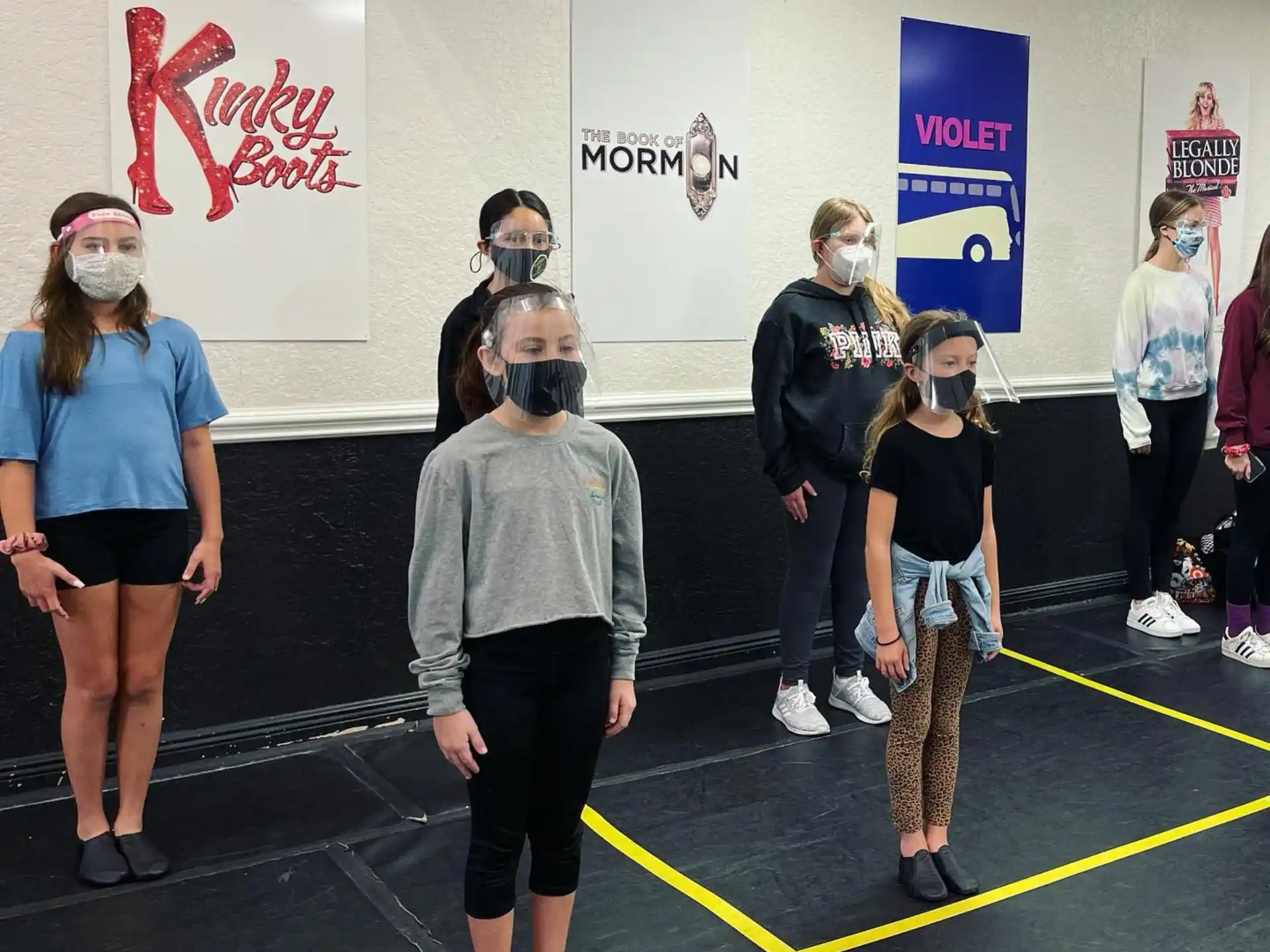 a group of people standing in a room with a yellow line