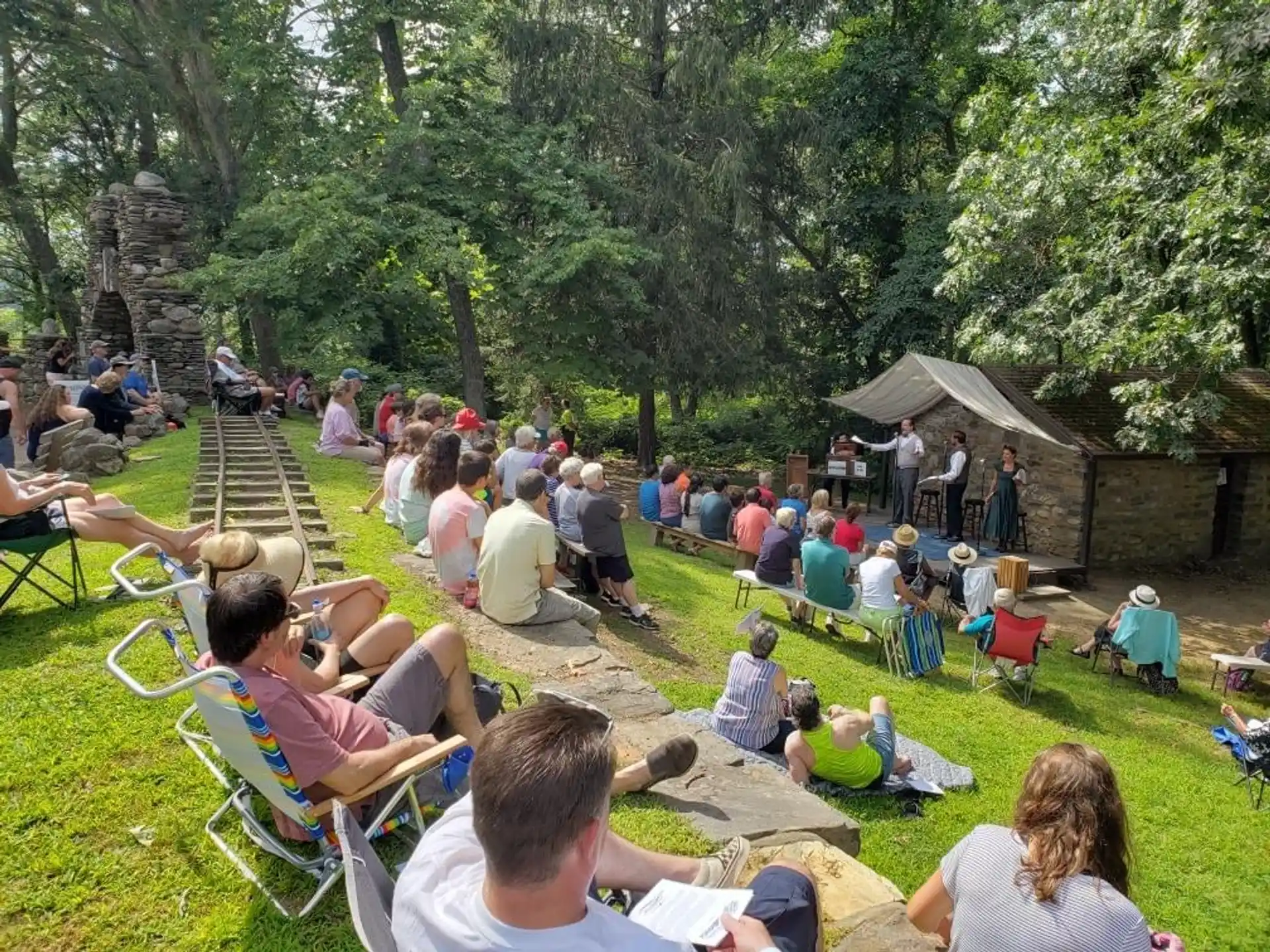 a group of people sitting on chairs in a park