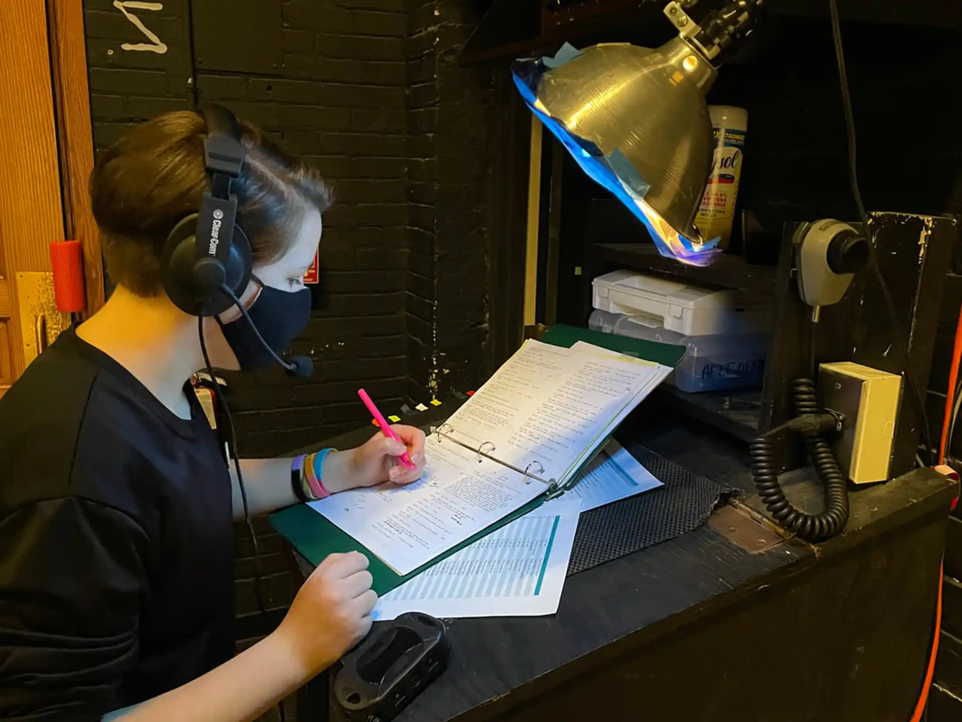 a person wearing headphones and writing on a piece of paper