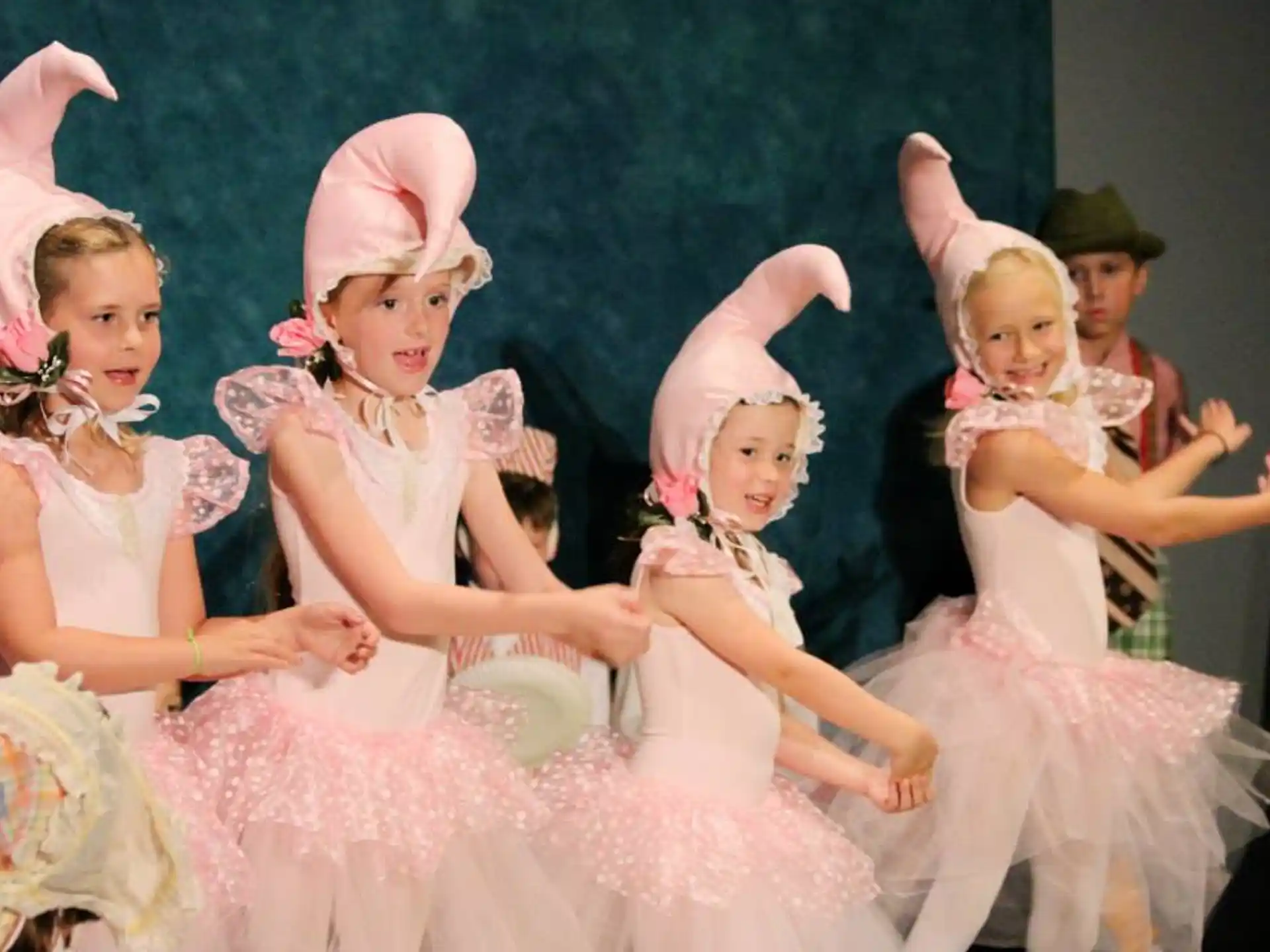 a group of girls wearing dresses and posing for a photo