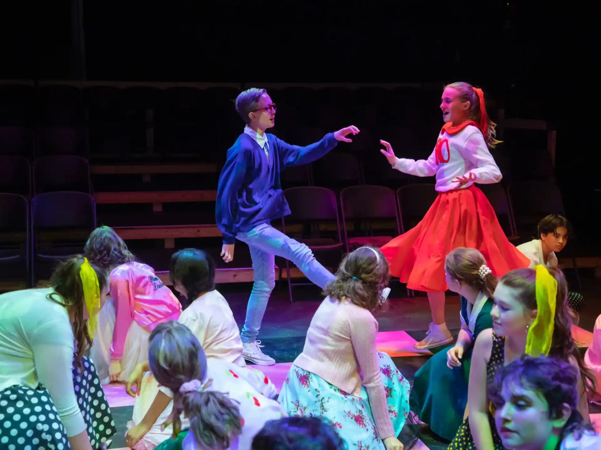a man and woman dancing on a stage with children