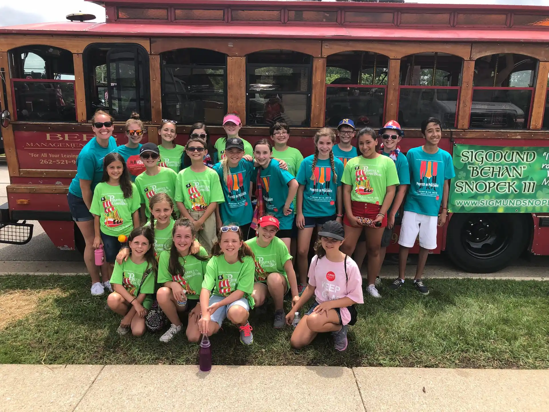 a group of people posing for a photo in front of a bus