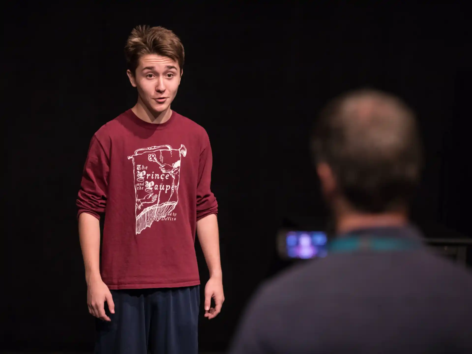 a man standing in front of a man in a red shirt