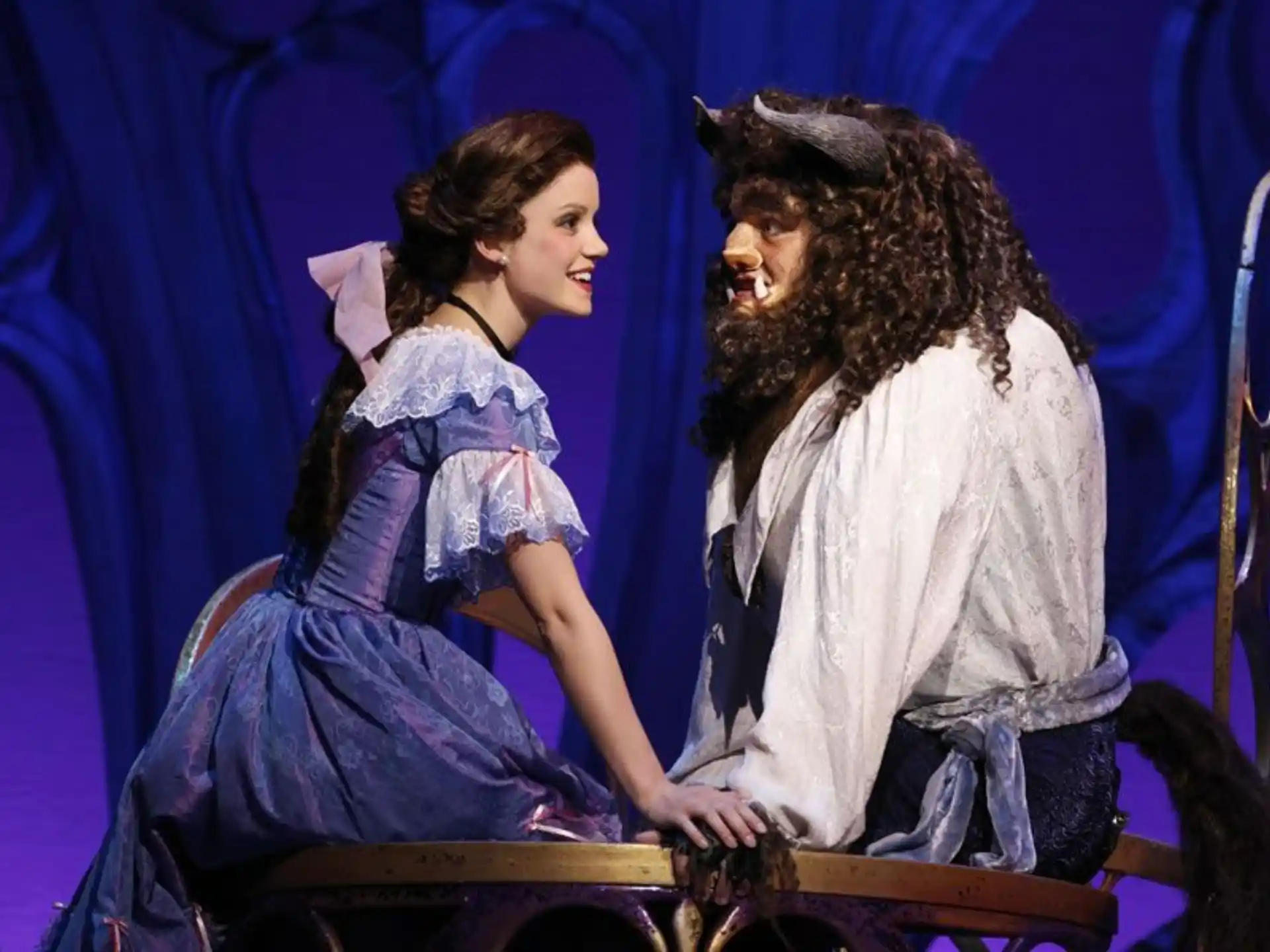 a man and woman sitting on a stage