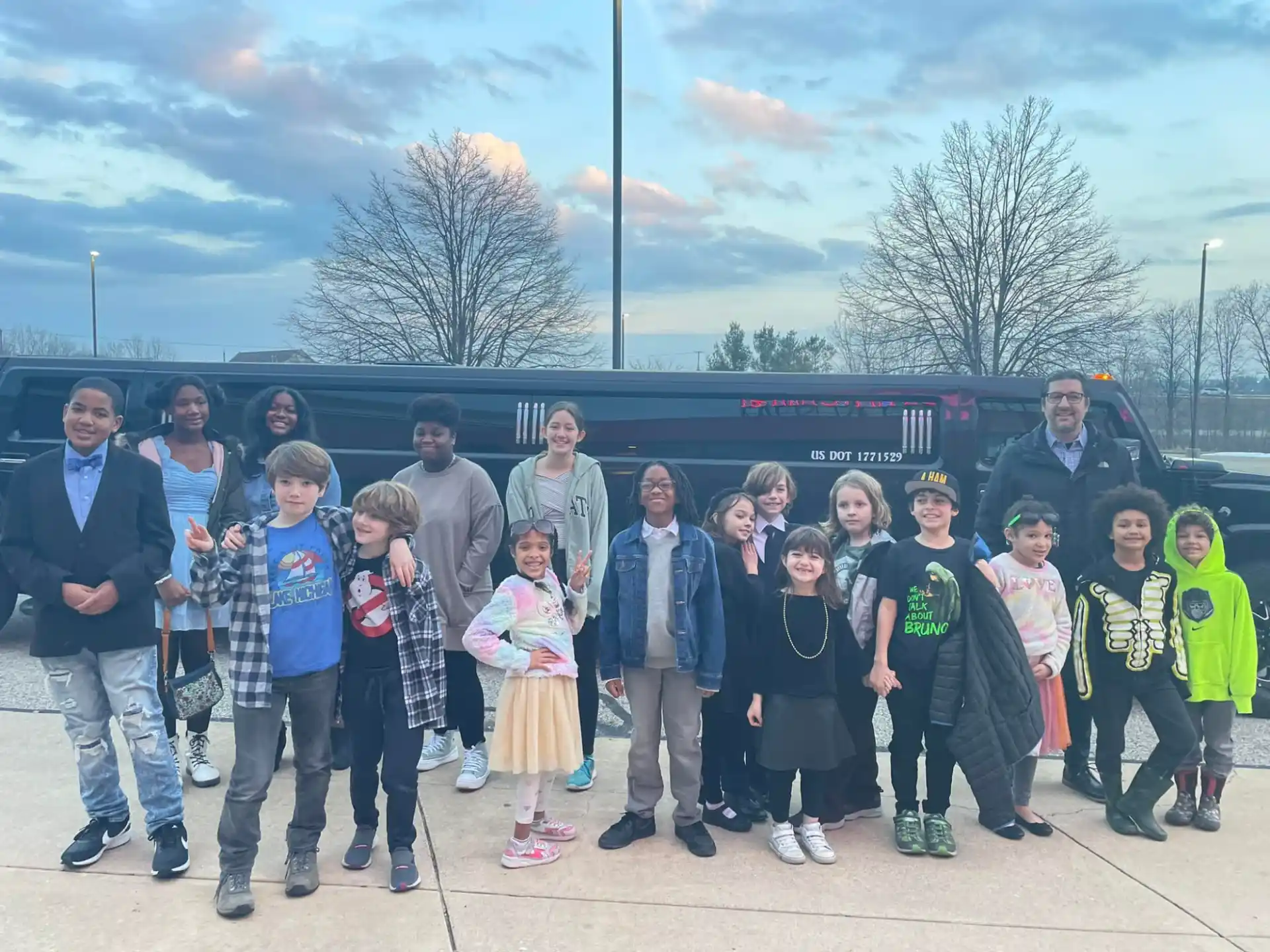 a group of people posing for a photo in front of a black bus