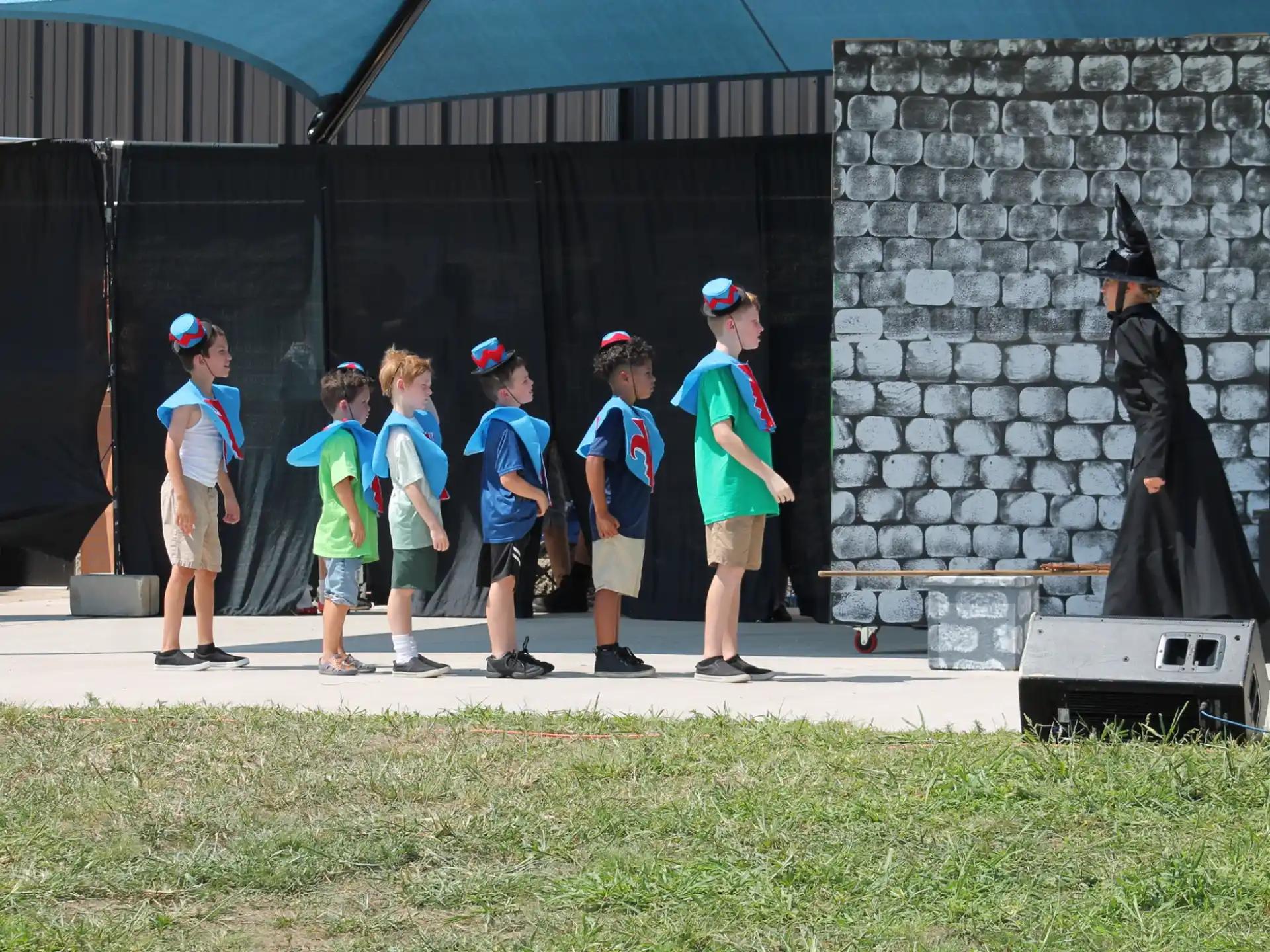 a group of kids standing in front of a statue