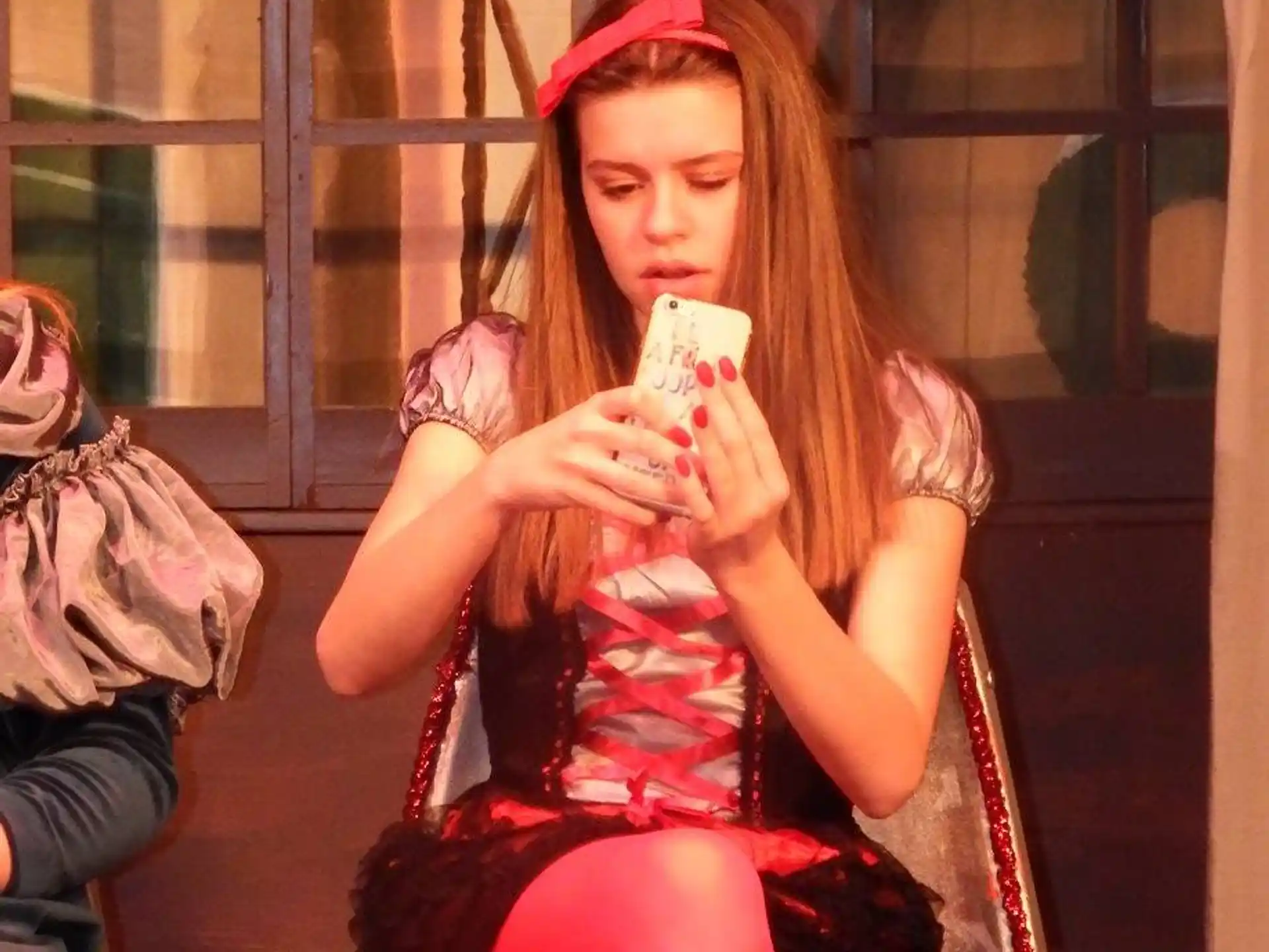a woman sitting on a chair and holding a phone