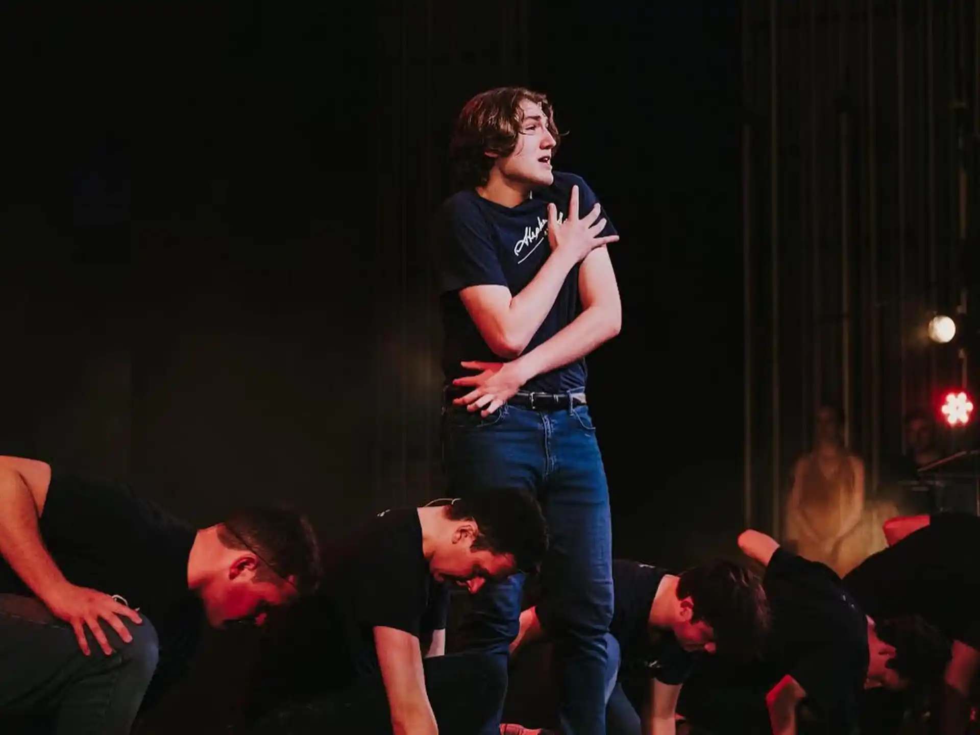 a person on a stage with a microphone and people around him