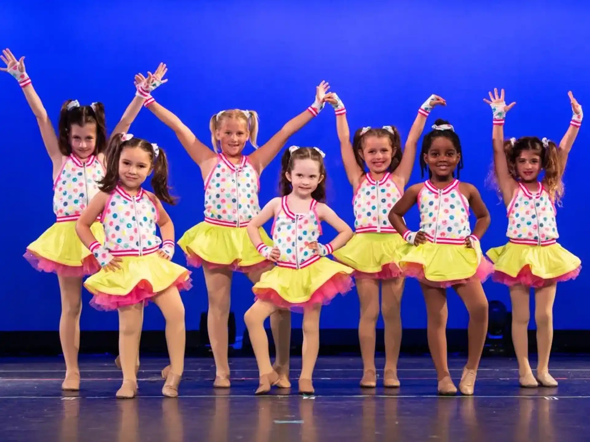 a group of girls in colorful skirts