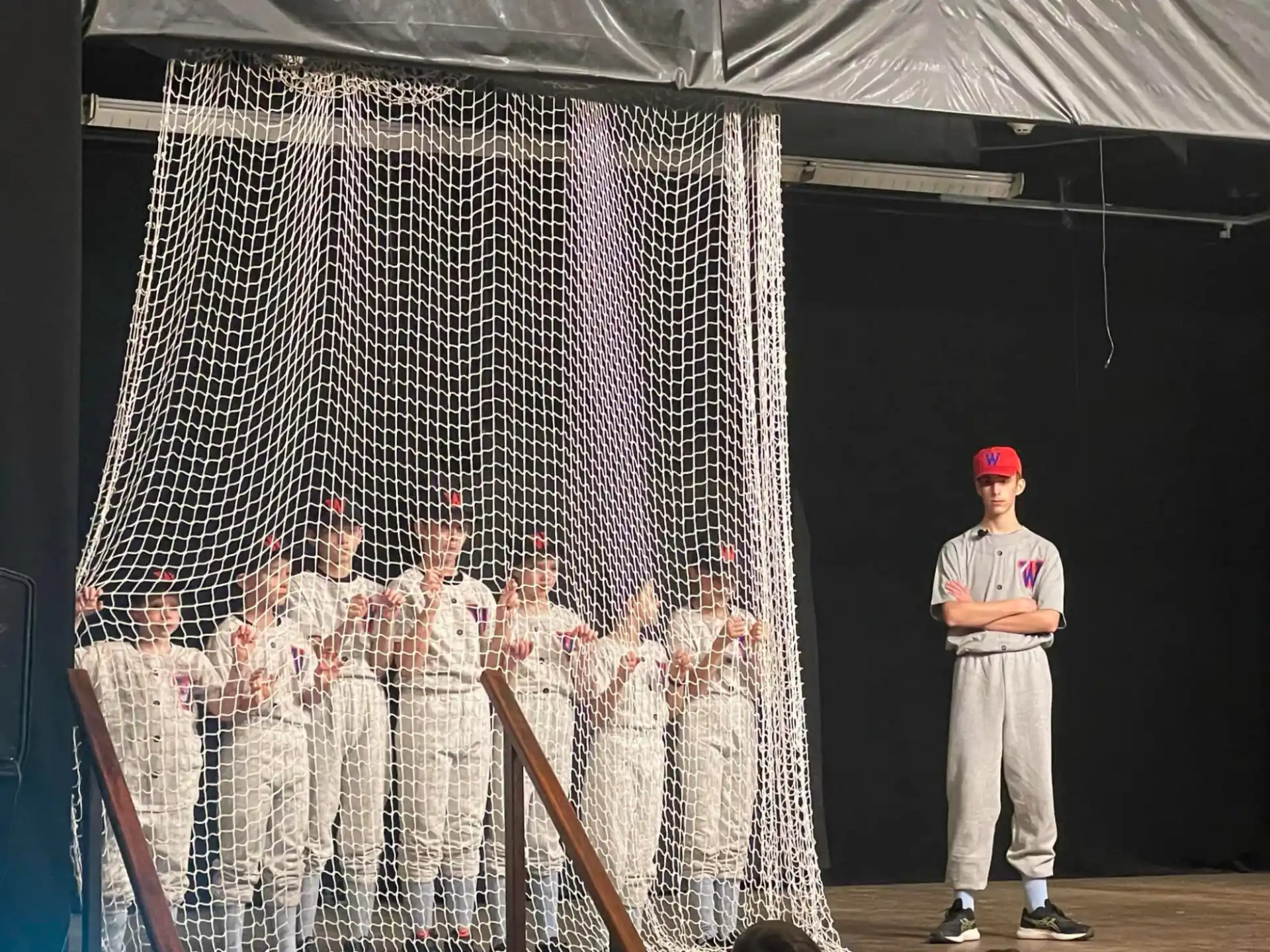 a baseball player standing in front of a net