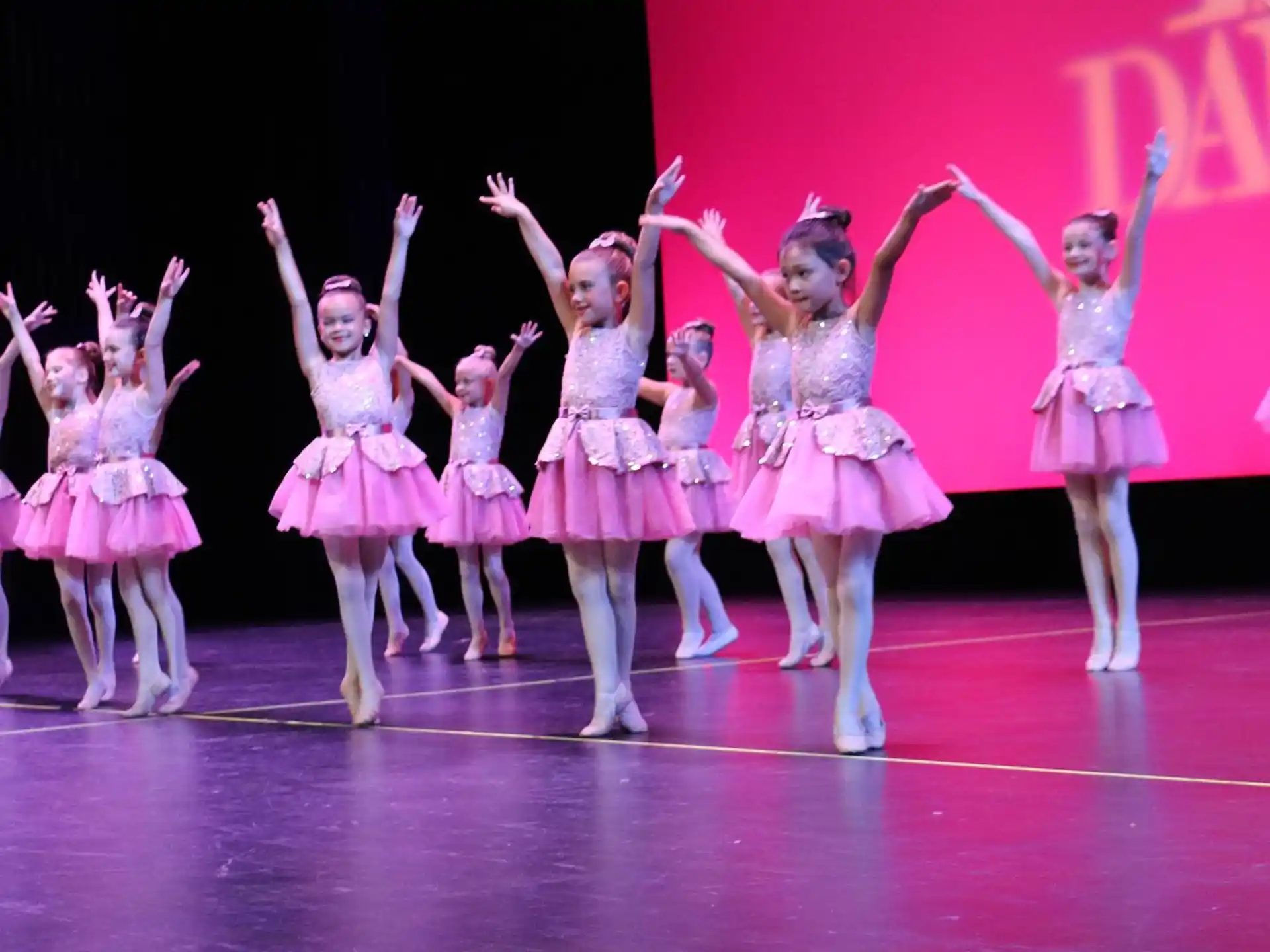 a group of women in dresses on a stage