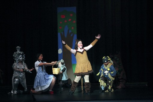 a person on stage with a group of people in clothing
