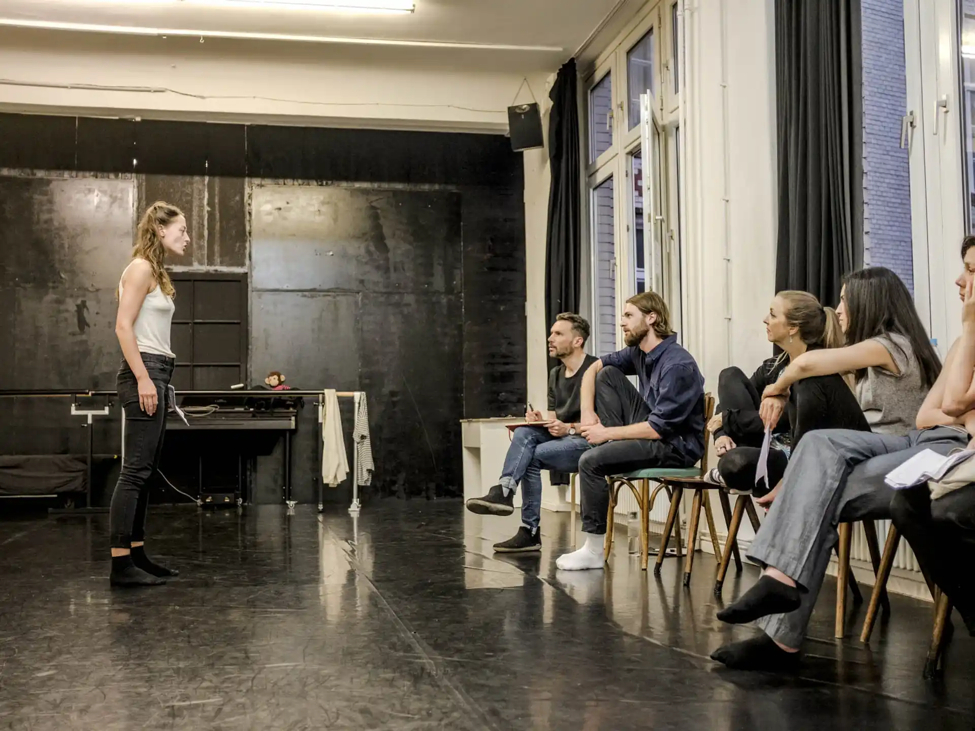 a person standing in front of a group of people sitting in chairs