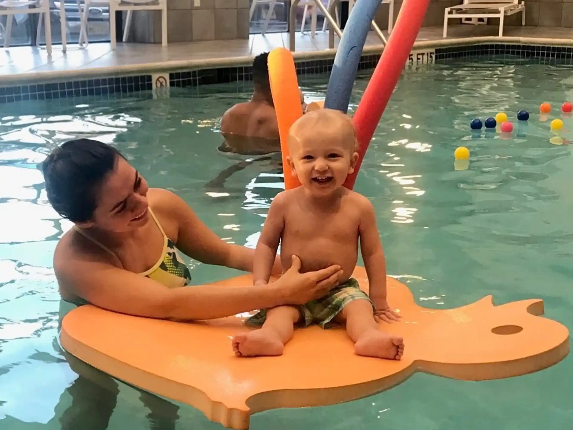 a person and a baby in a pool