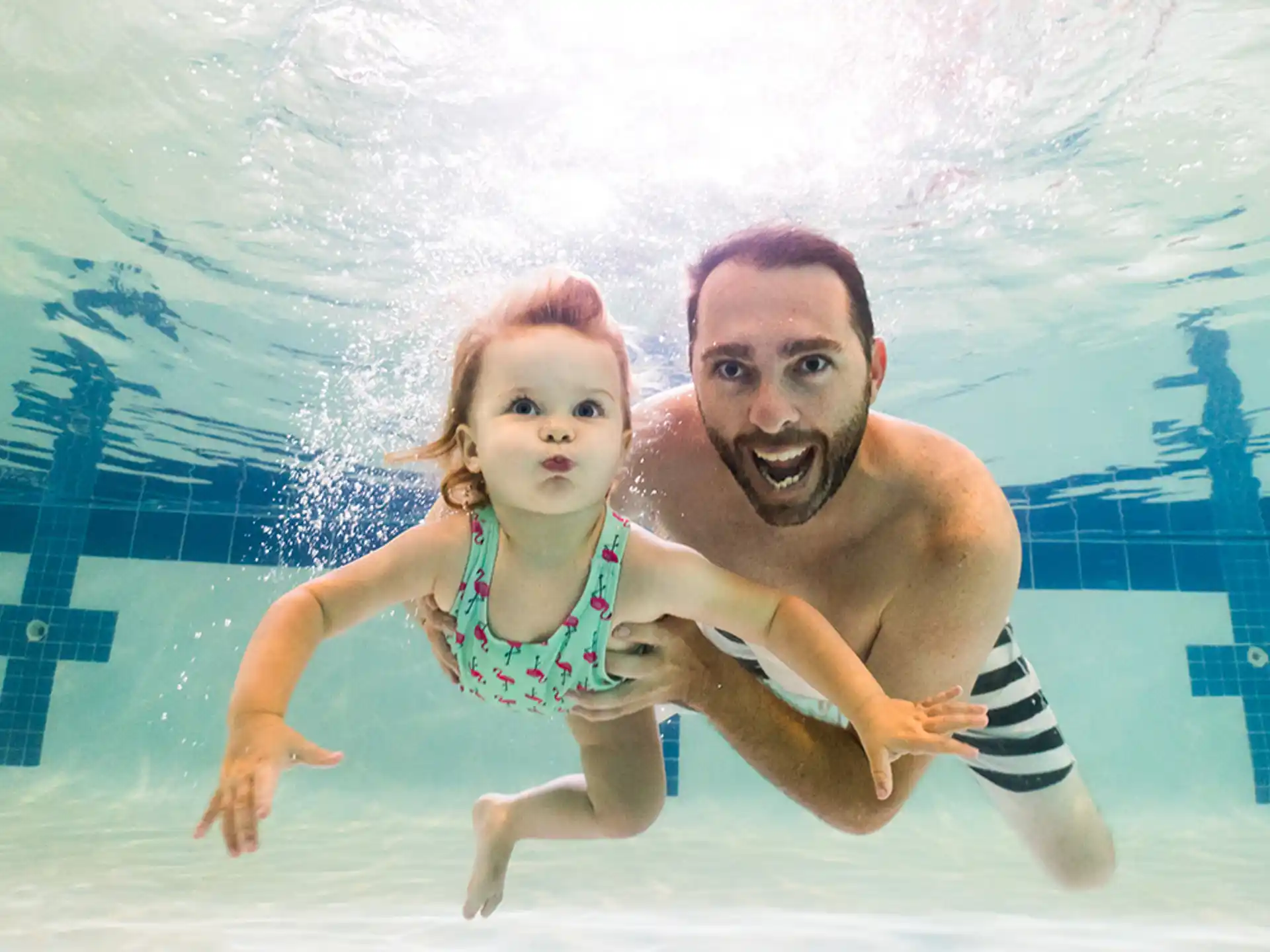 a person and a girl in a pool