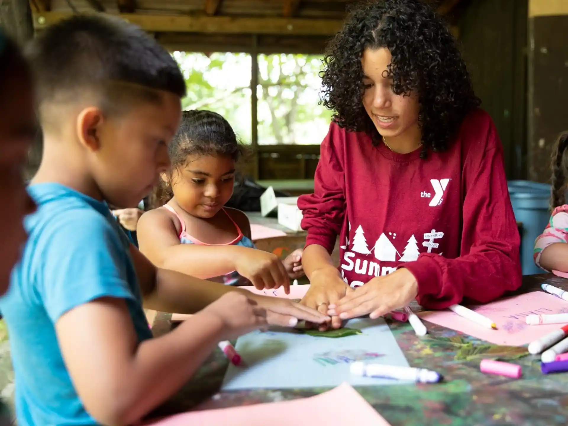 a person and children sitting at a table looking at a paper