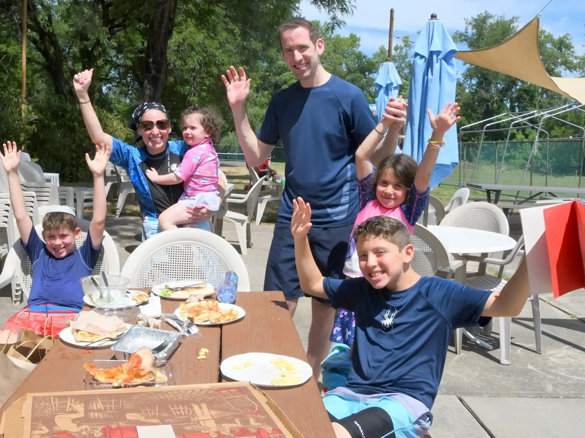 a group of people at a picnic table with food