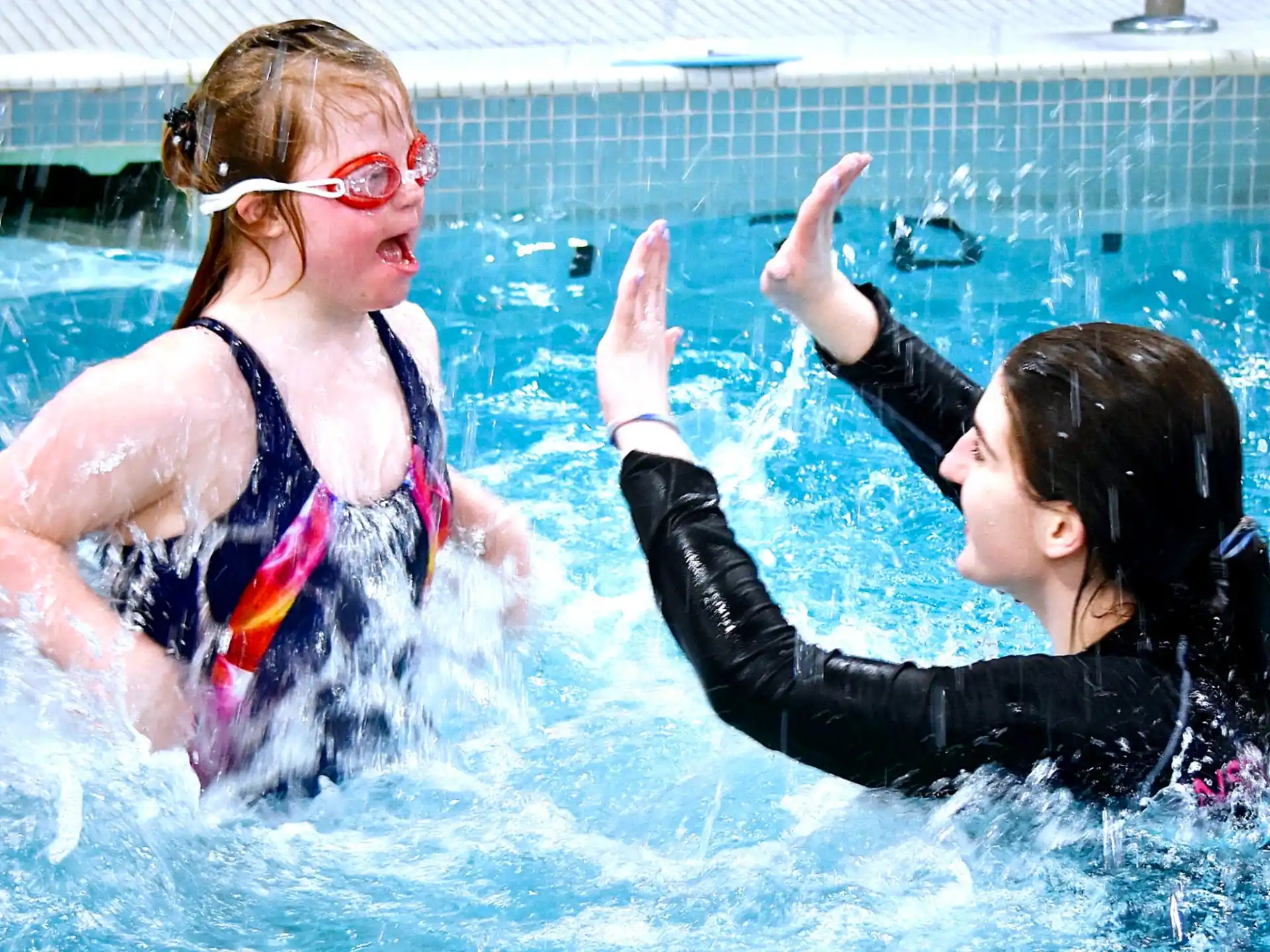 a person and a girl in a pool