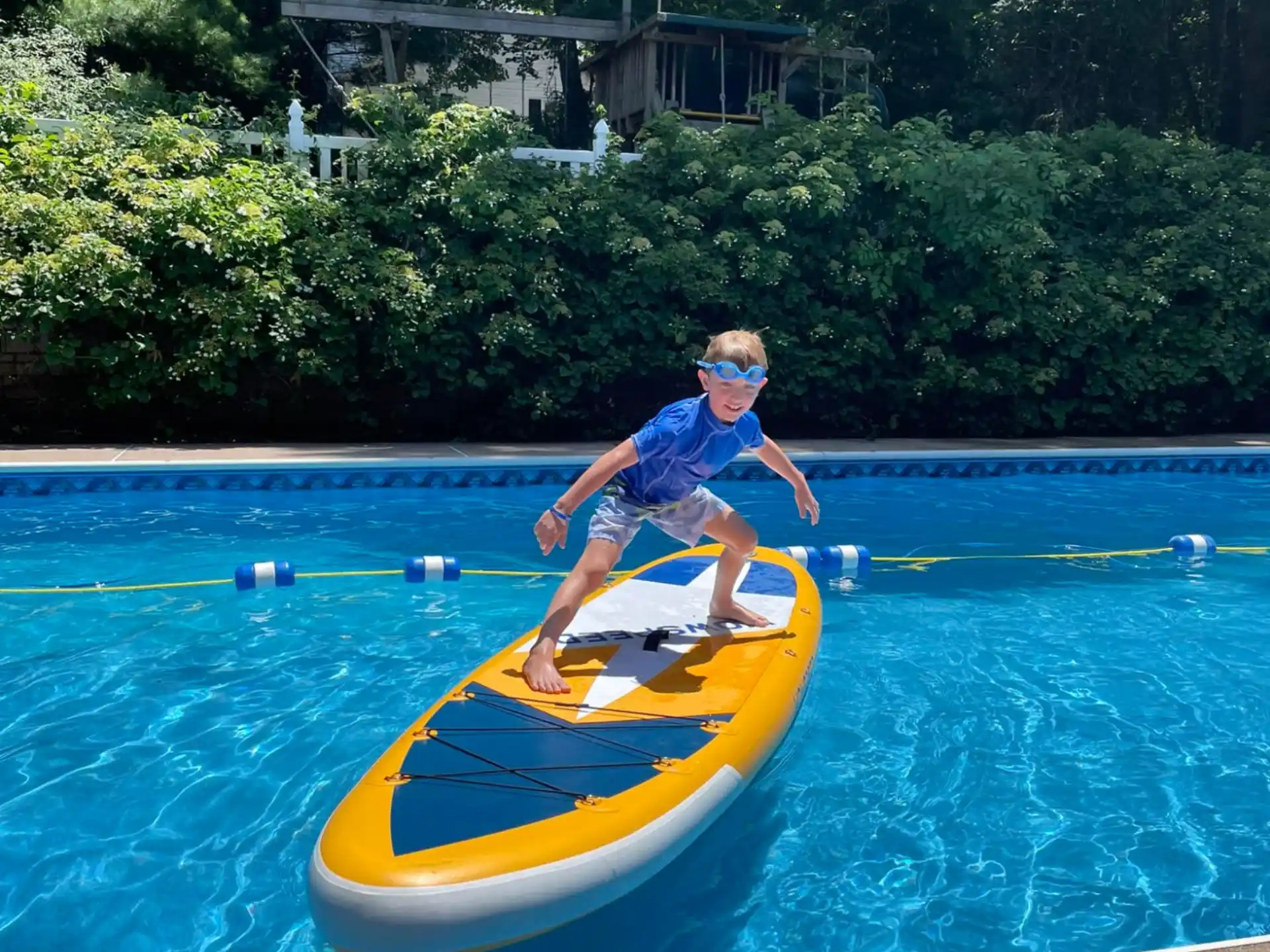 a boy on a surfboard in a pool