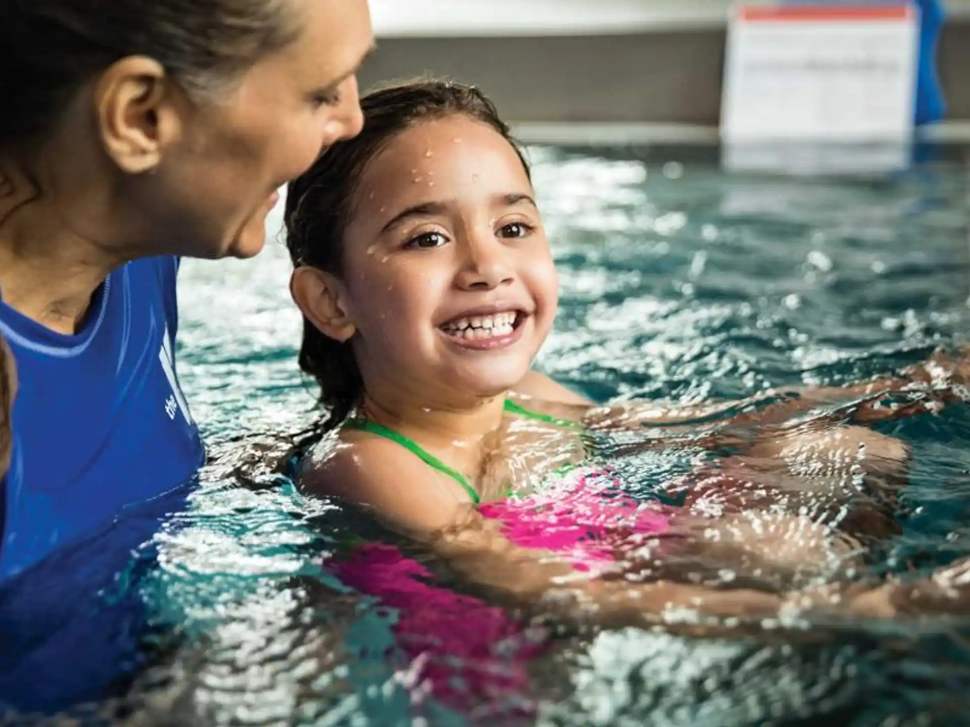 a woman and a girl in a pool