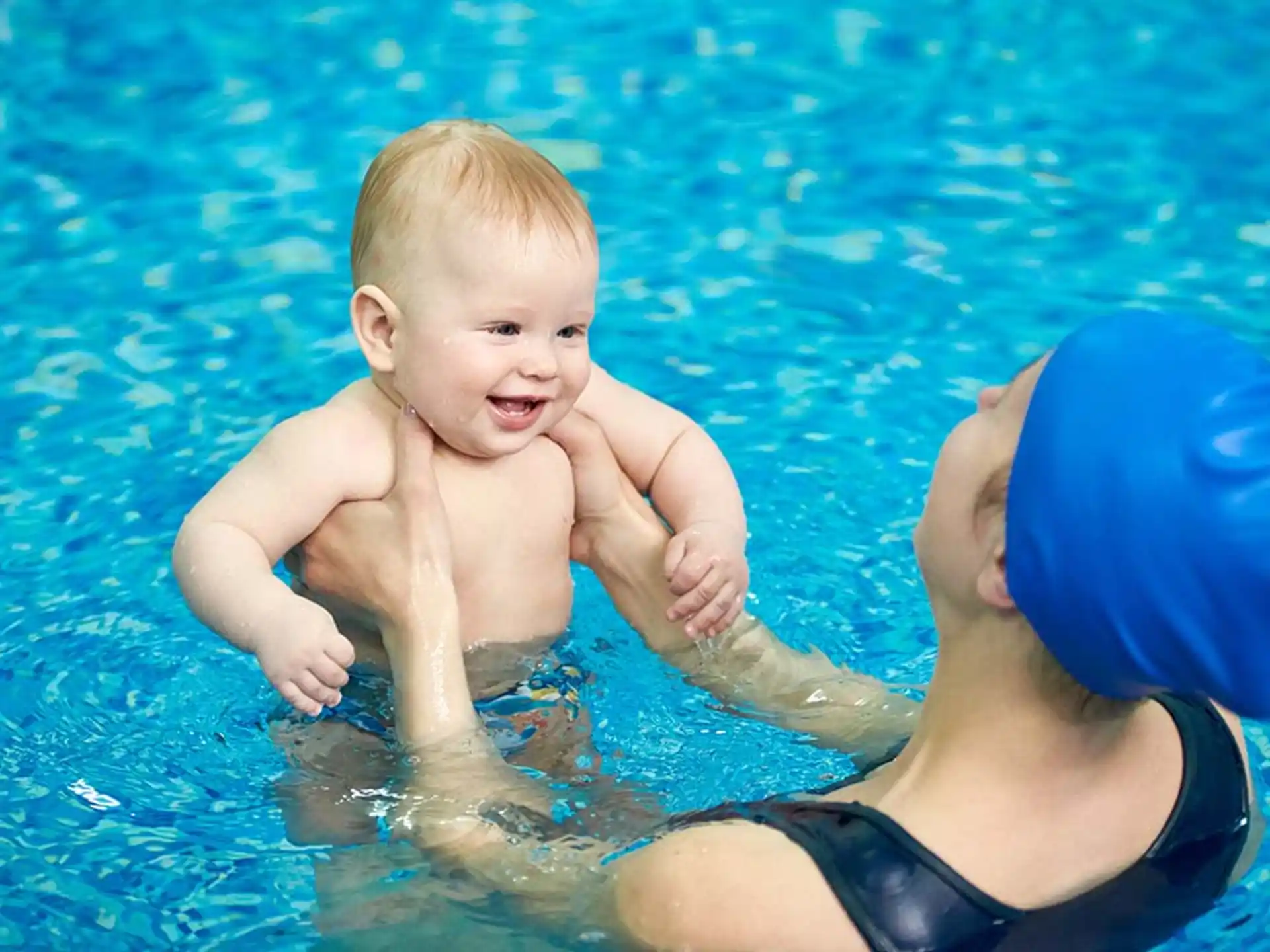 a person and a baby in a pool