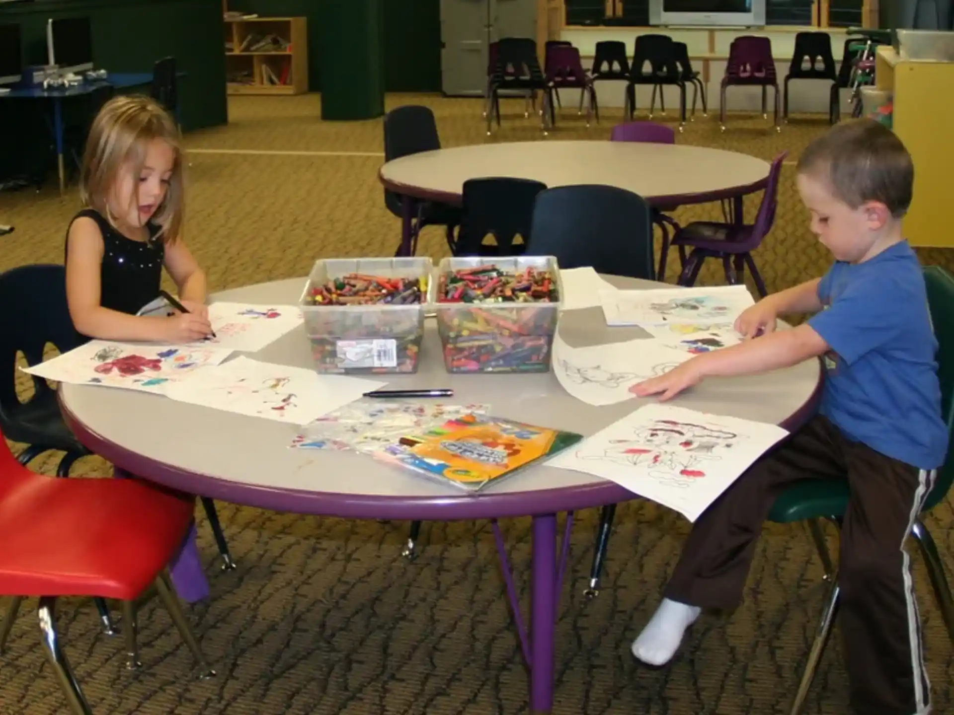 a group of children sitting at a table with a game board