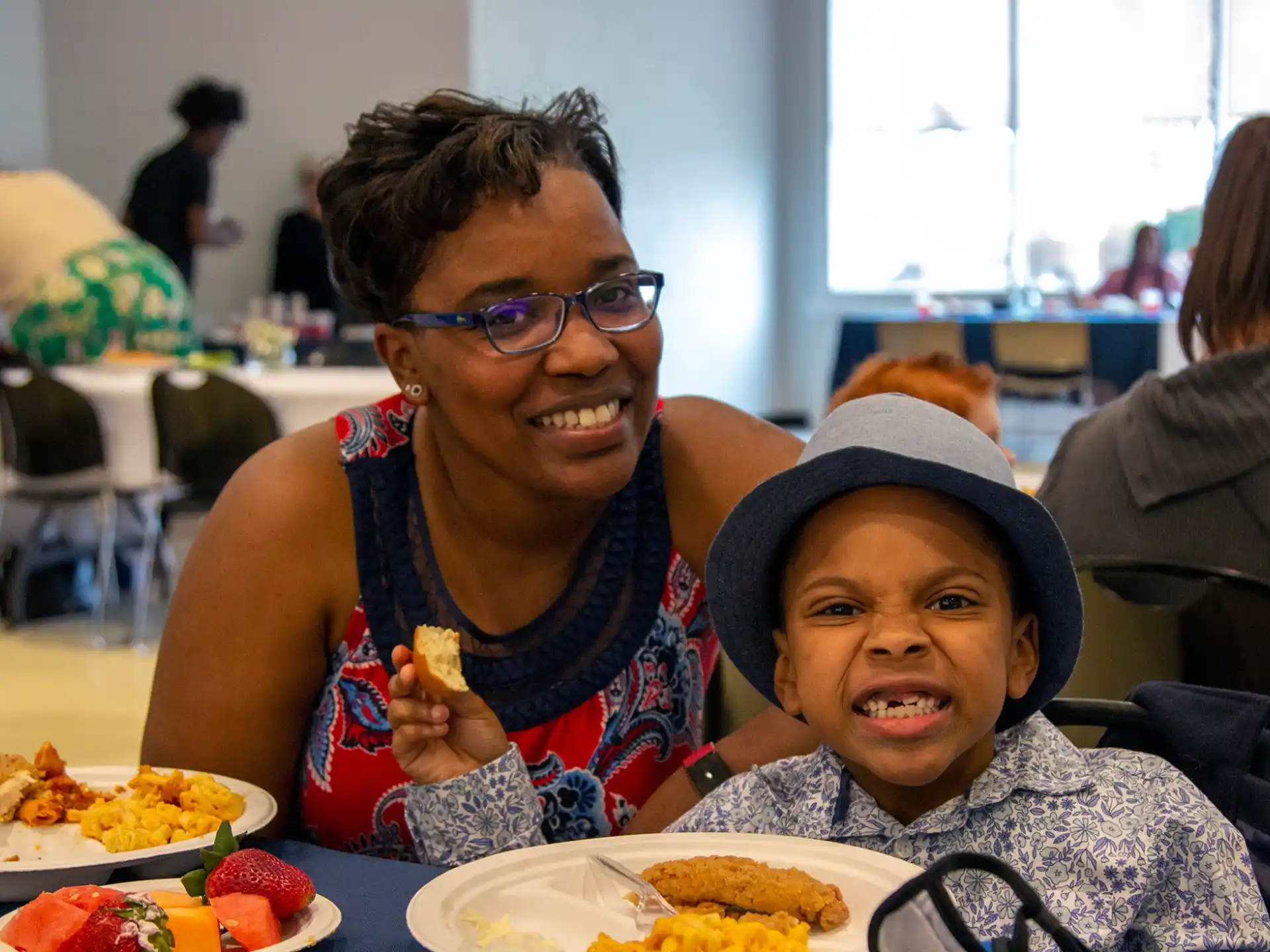 a person and a boy sitting at a table with food