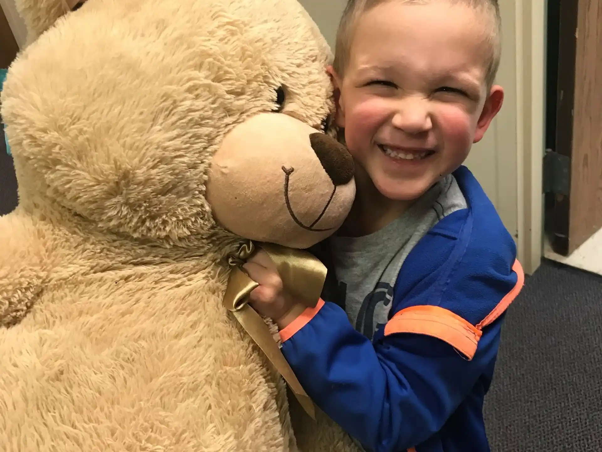 a boy holding a large teddy bear