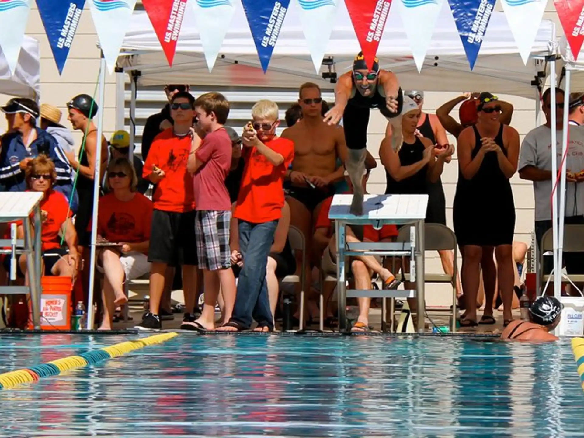 a group of people standing around a pool