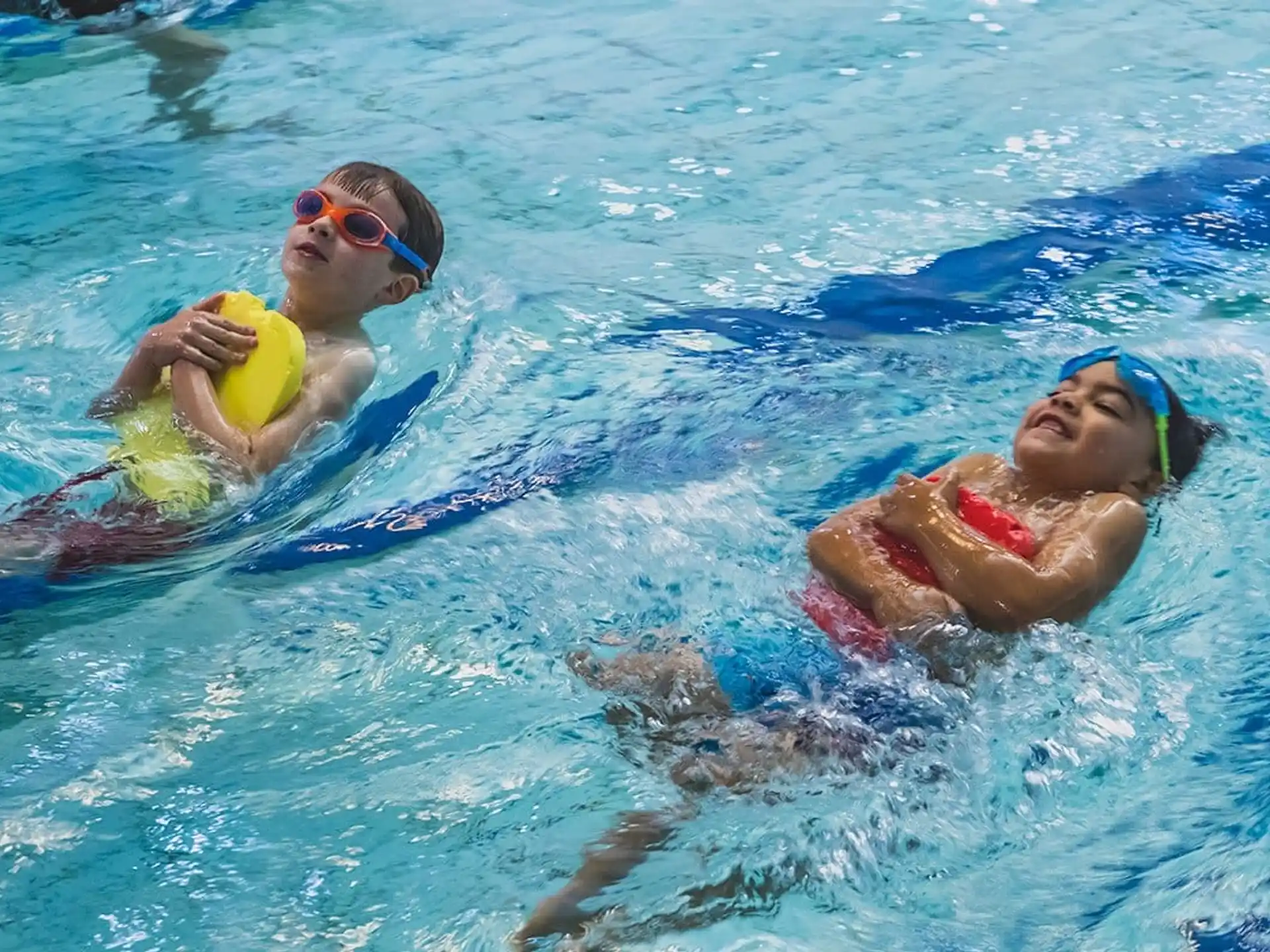 a couple of people swimming in a pool